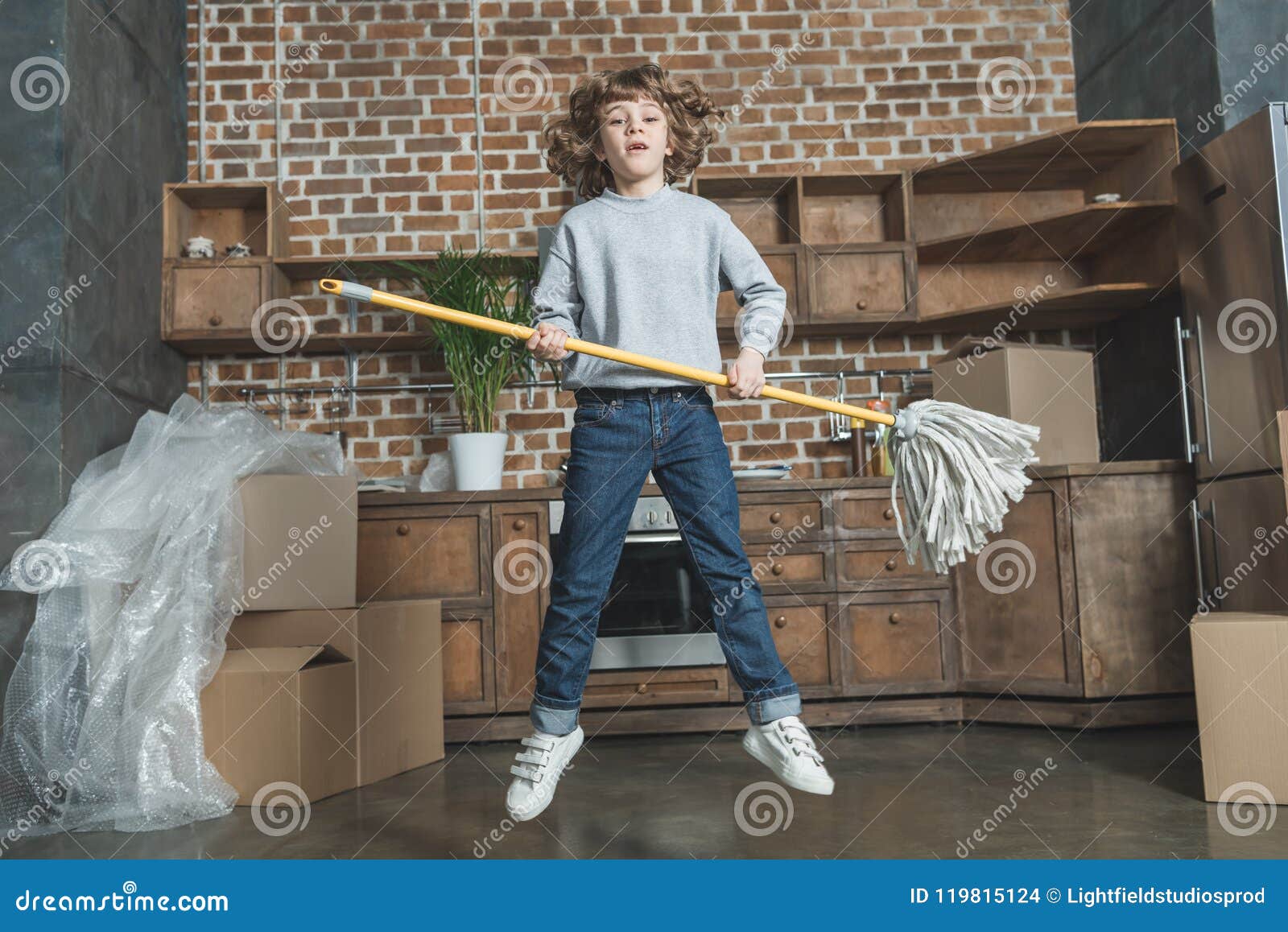 Happy Little Boy Jumping with Mop Stock Photo - Image of packaging ...