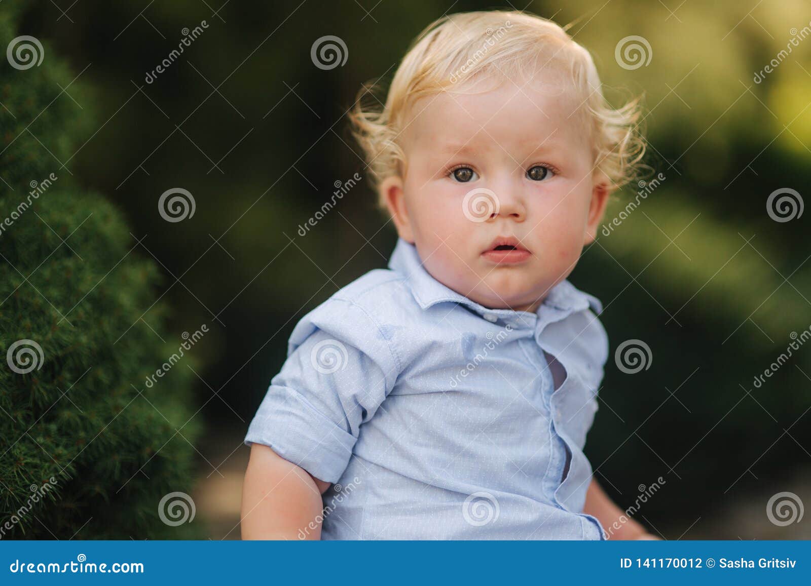 Happy Little Boy Sit Outside In Summer Time Boy With Curly Blond