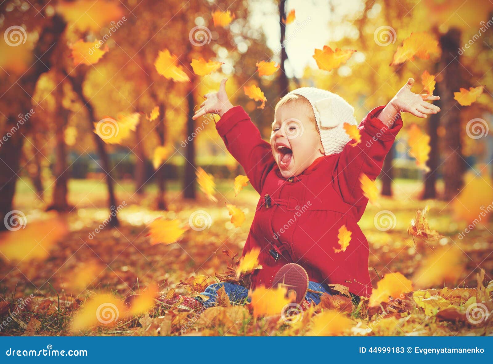 happy little child, baby girl laughing and playing in autumn