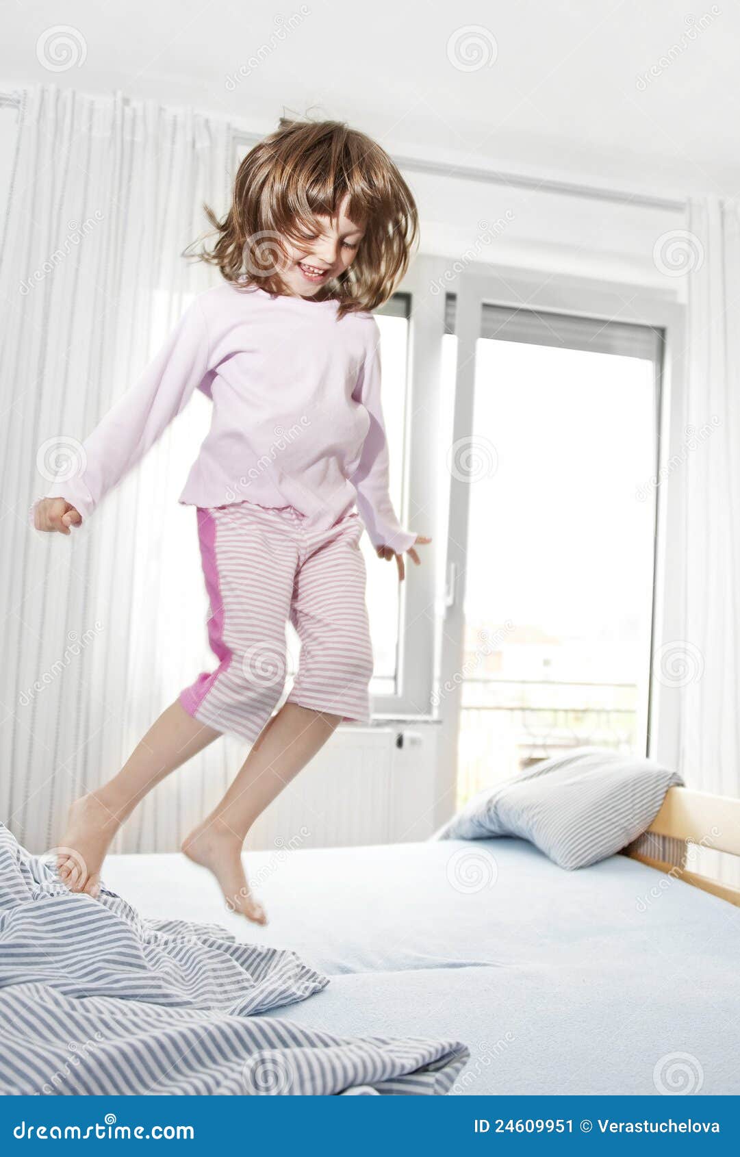 Happy Little Girl Jumping on a Bed Stock Image Image of child, life