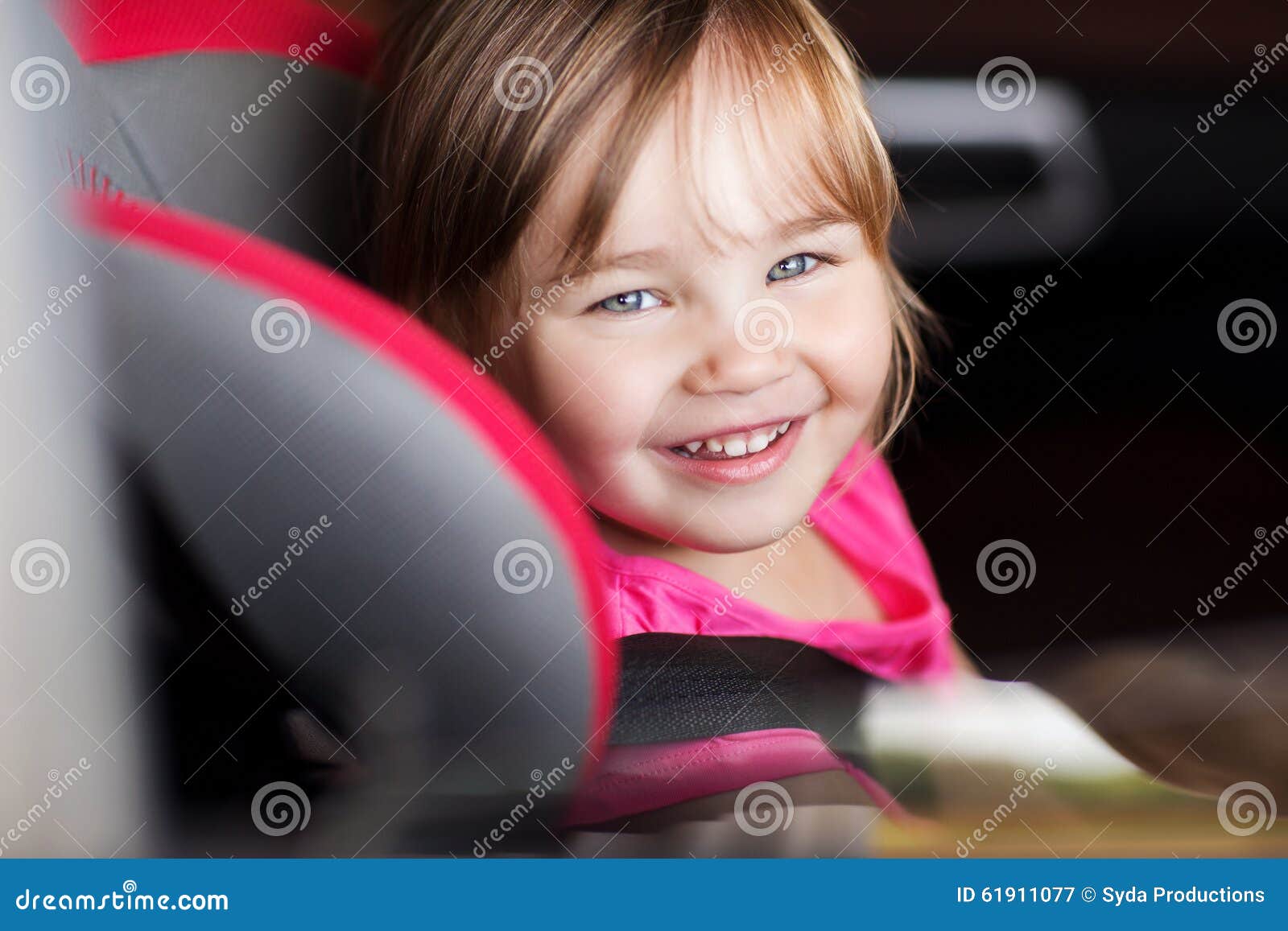 happy little girl sitting in baby car seat