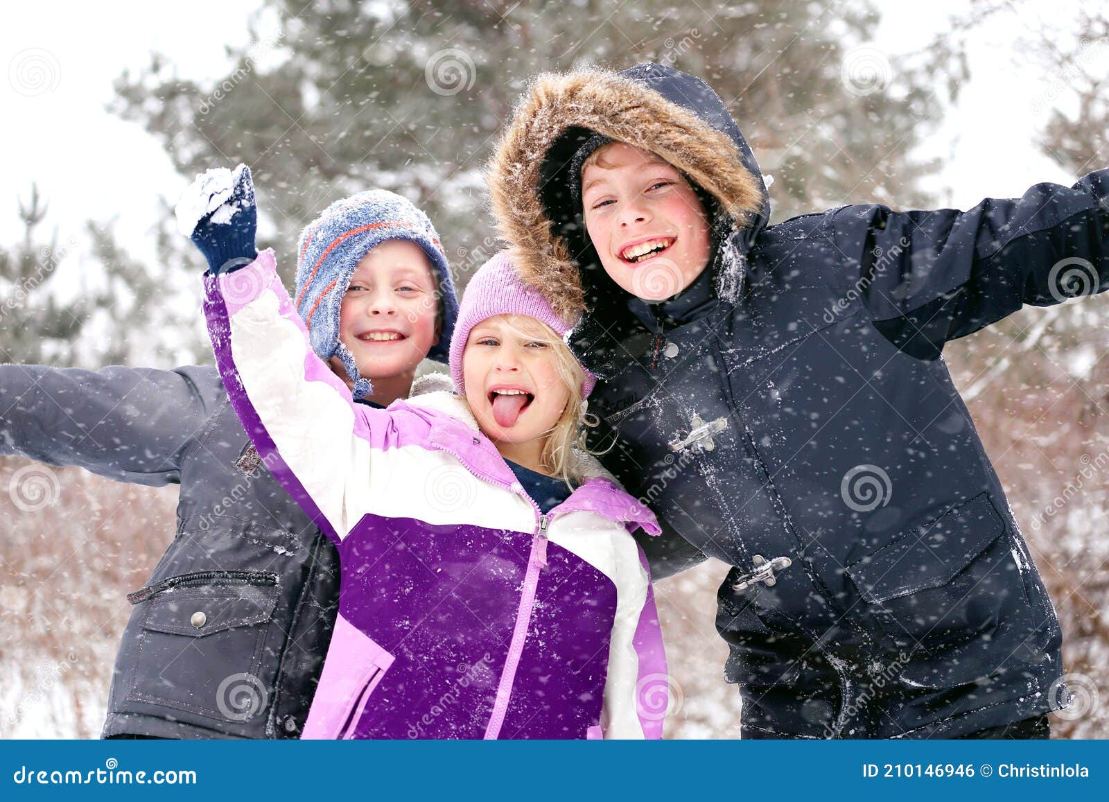 happy little kids playing outside in the winter snow