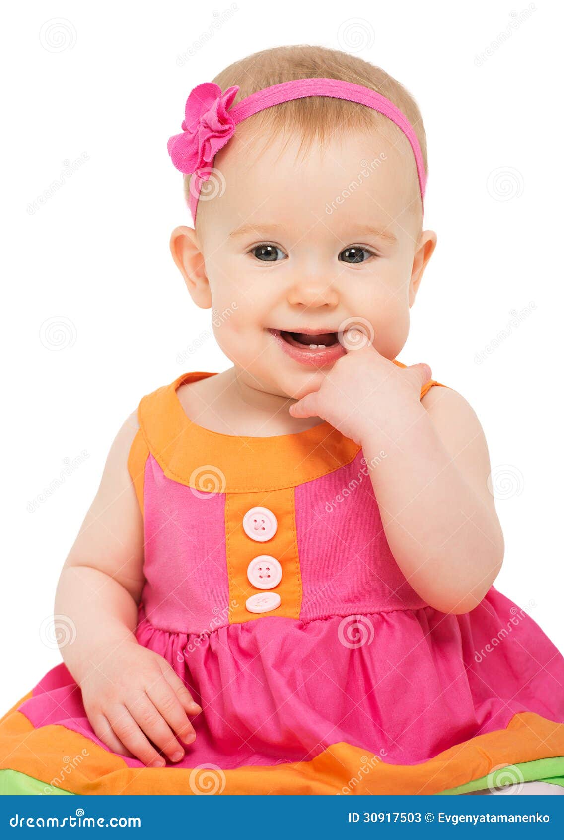 happy little sly baby girl in bright multicolored festive dress