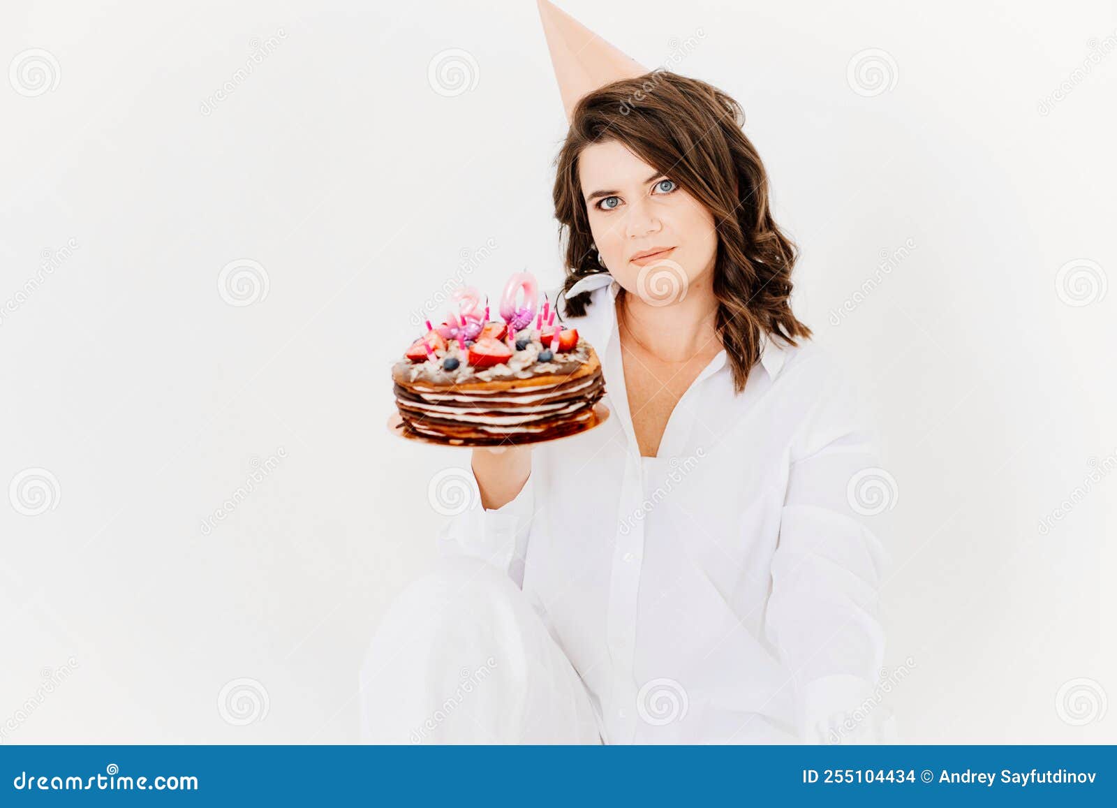 A Happy Lonely Woman with a Birthday Cake with Candles on a White ...