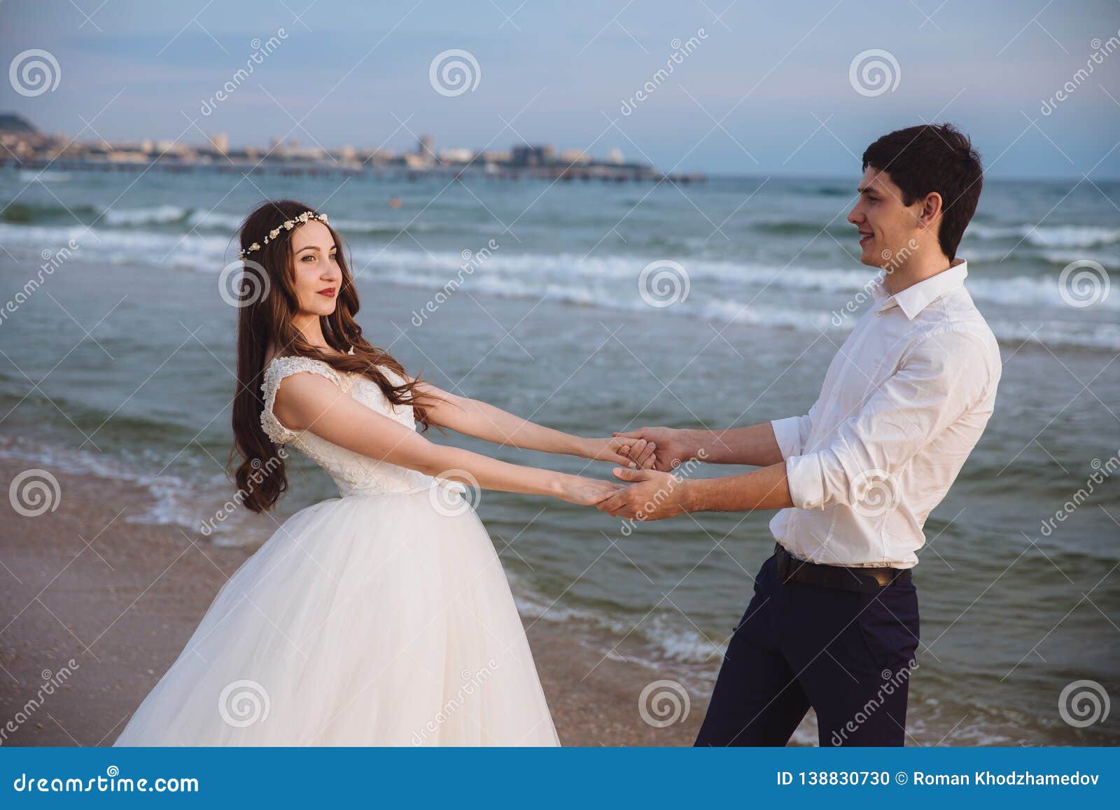 Happy Loving Couple Newlyweds Hold Each Others Hands On Ocean Beach