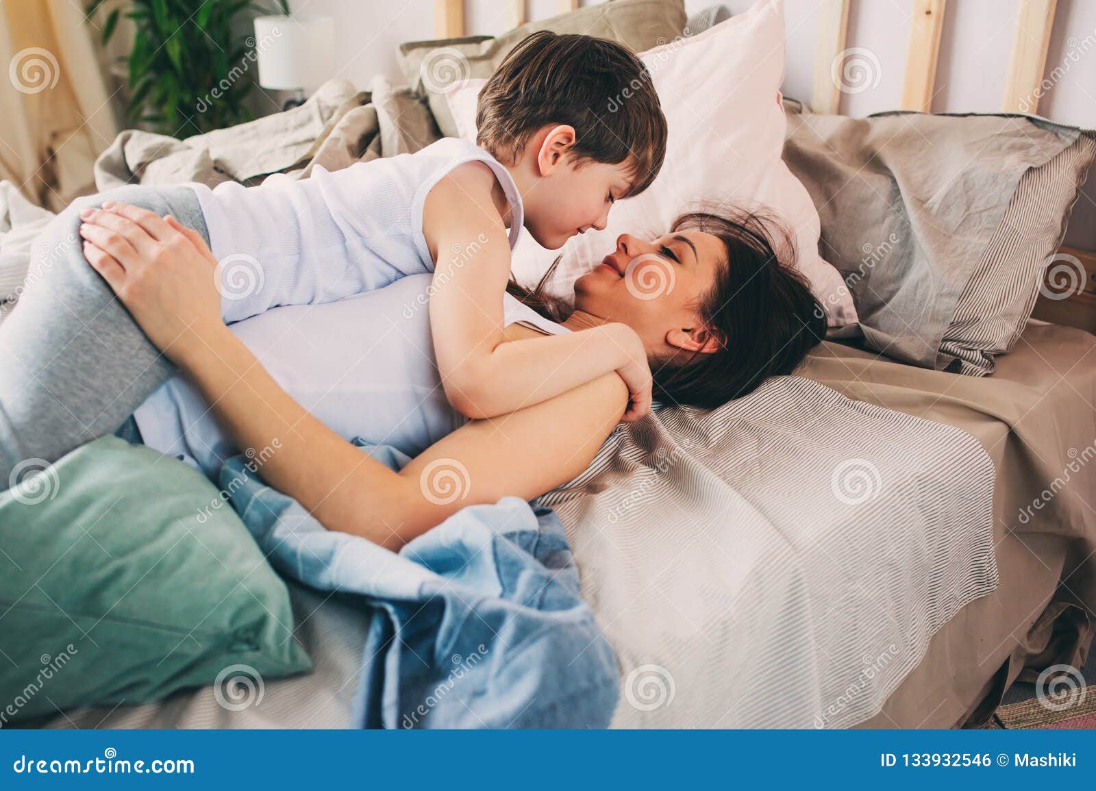 Happy Loving Mother Hugs with Child Son in the Morning in Bed ...