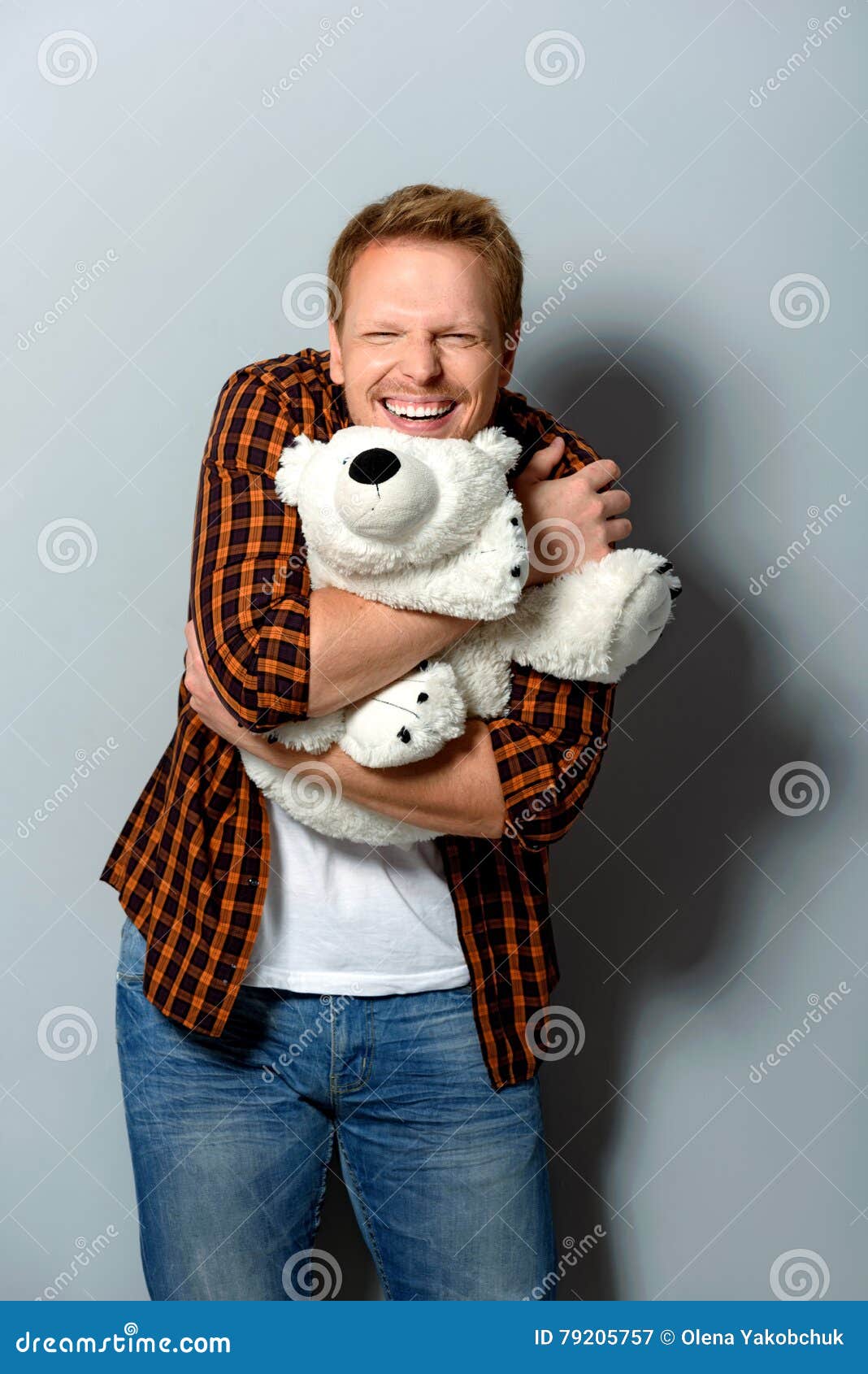 happy-male-hugging-toy-smiling-adult-person-looking-camera-holding-big-teddy-bear-79205757.jpg