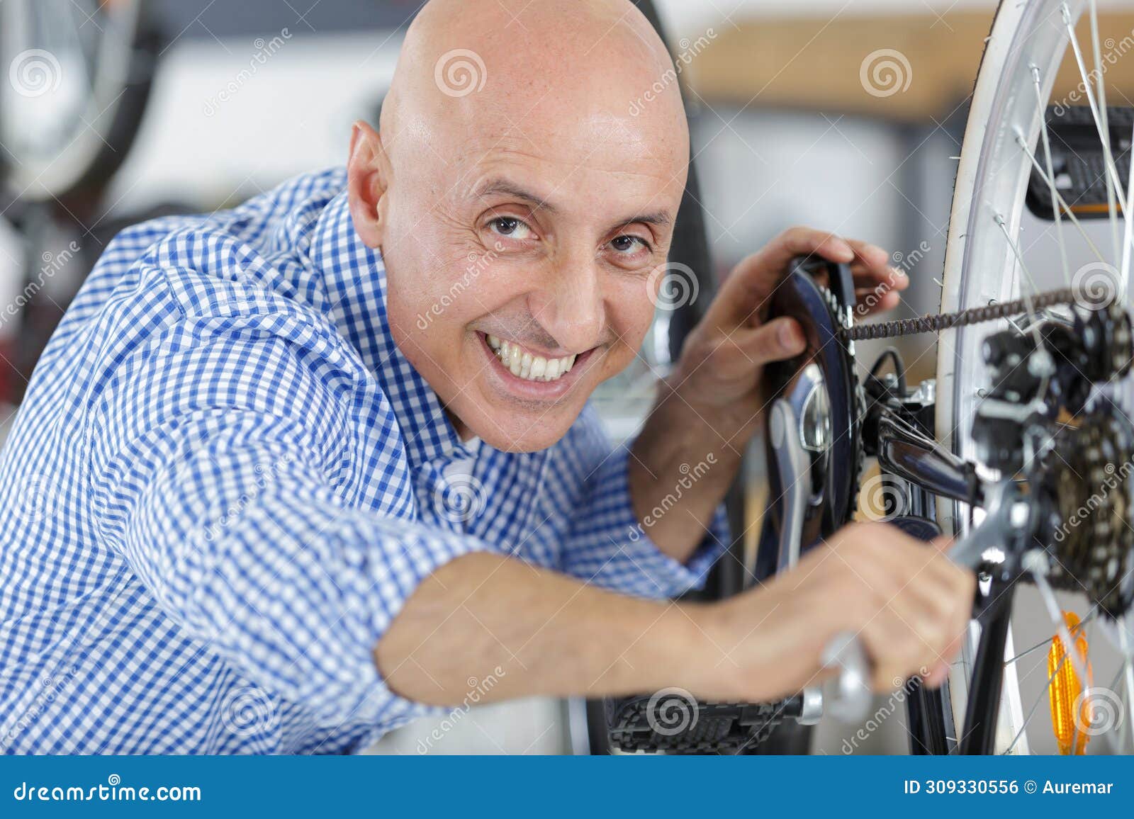 happy man fixing bike wheel in store