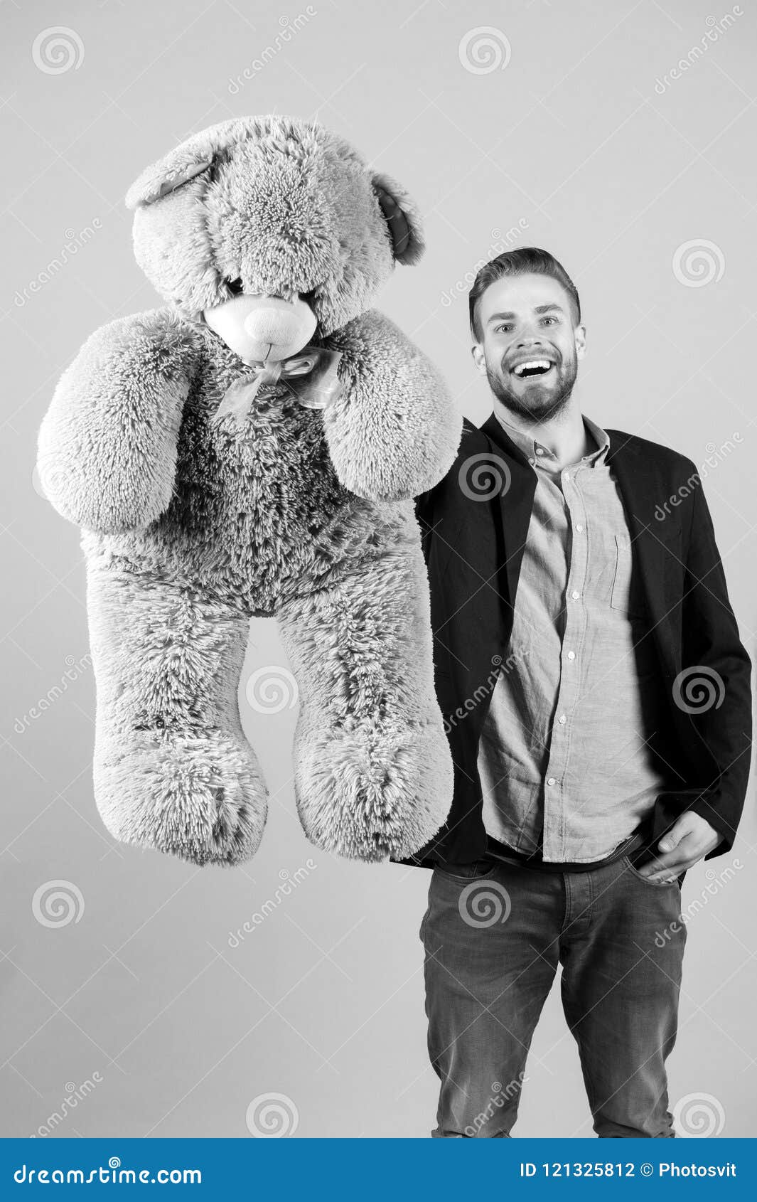 happy man with grey teddy bear. macho smile with big animal toy. gift and present concept. fashion and style. birthday