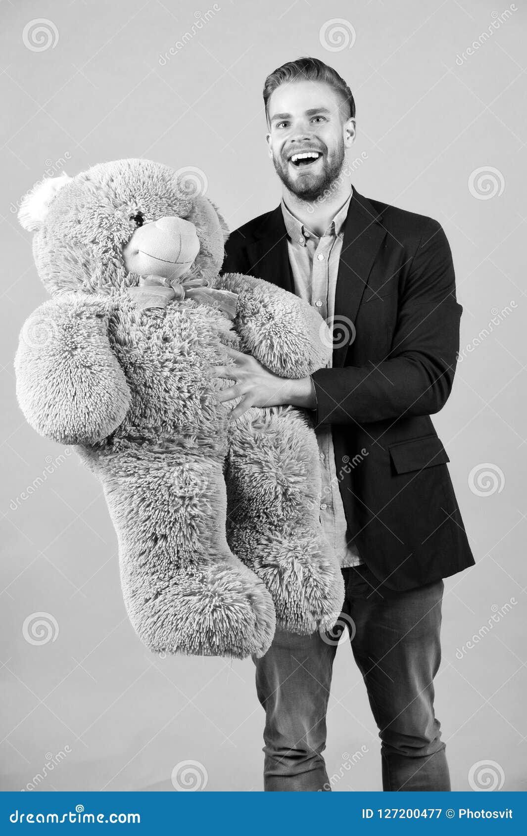 happy man hold grey teddy bear. macho smile with big animal toy. thisi is for you. gift and present concept. birthday