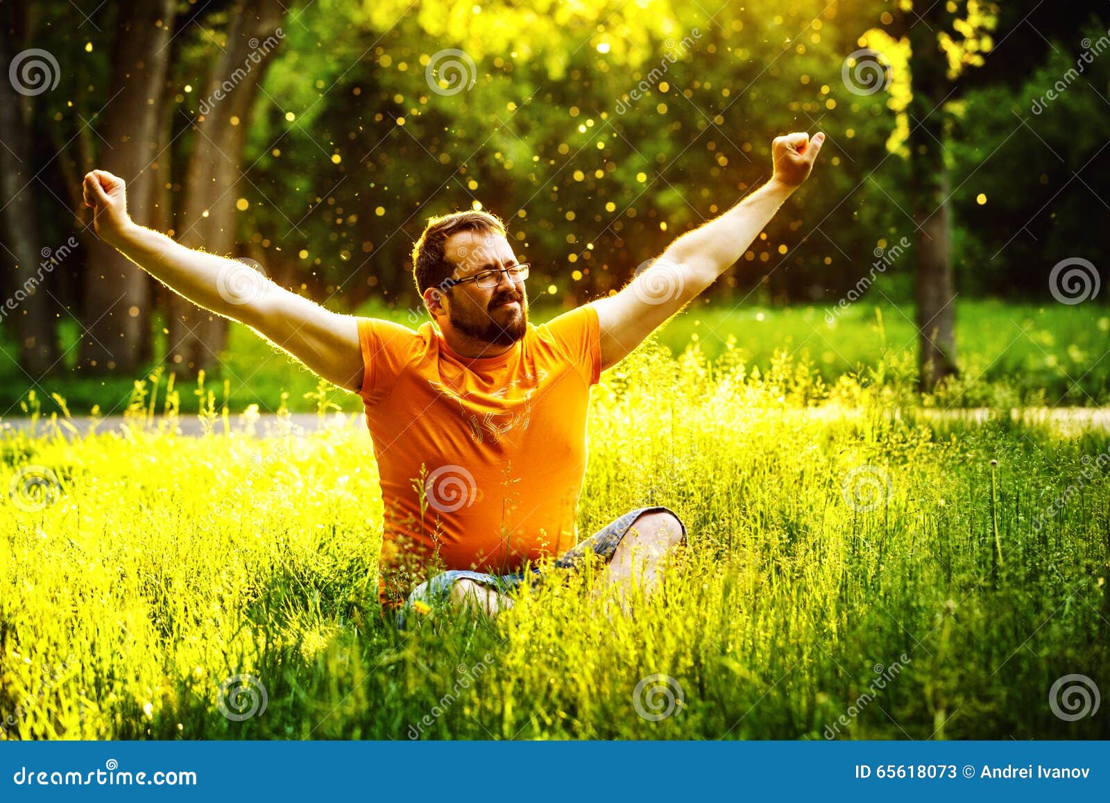 a happy man is relaxing on green grass with squint eyes