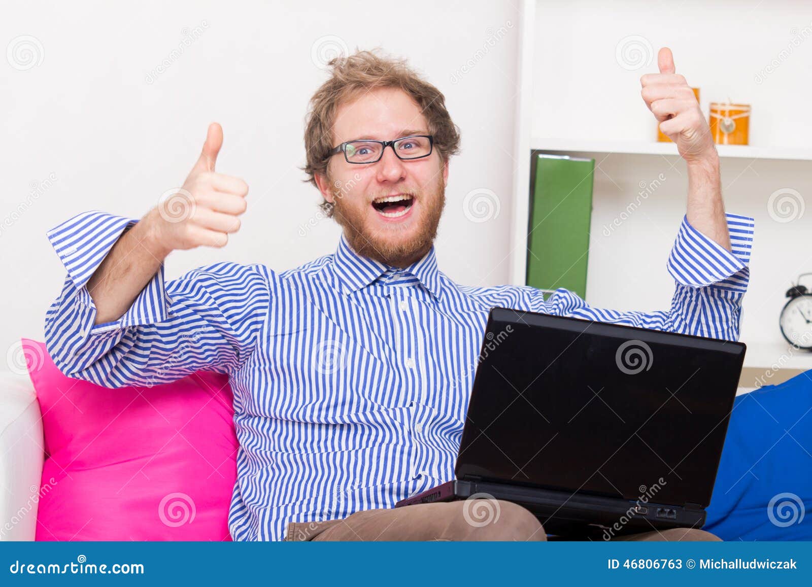 happy man shows ok sign in front of a computer