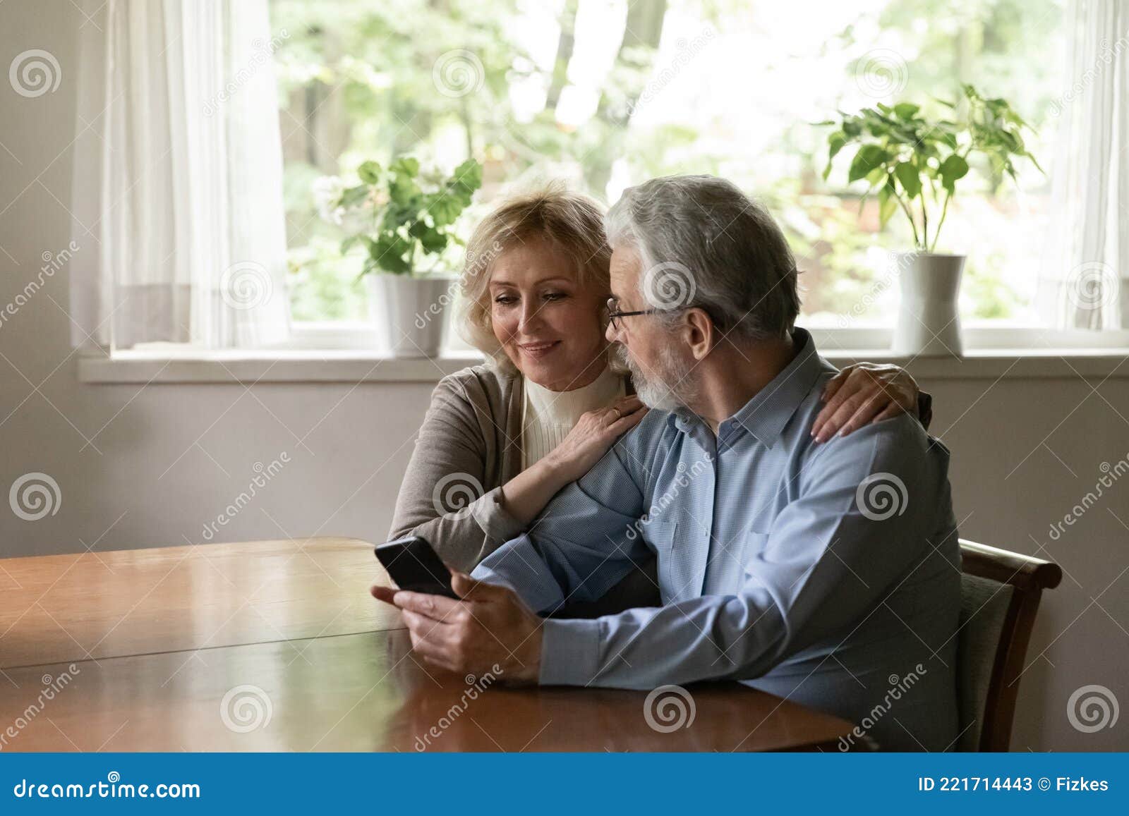 happy mature couple use smartphone gadget at home