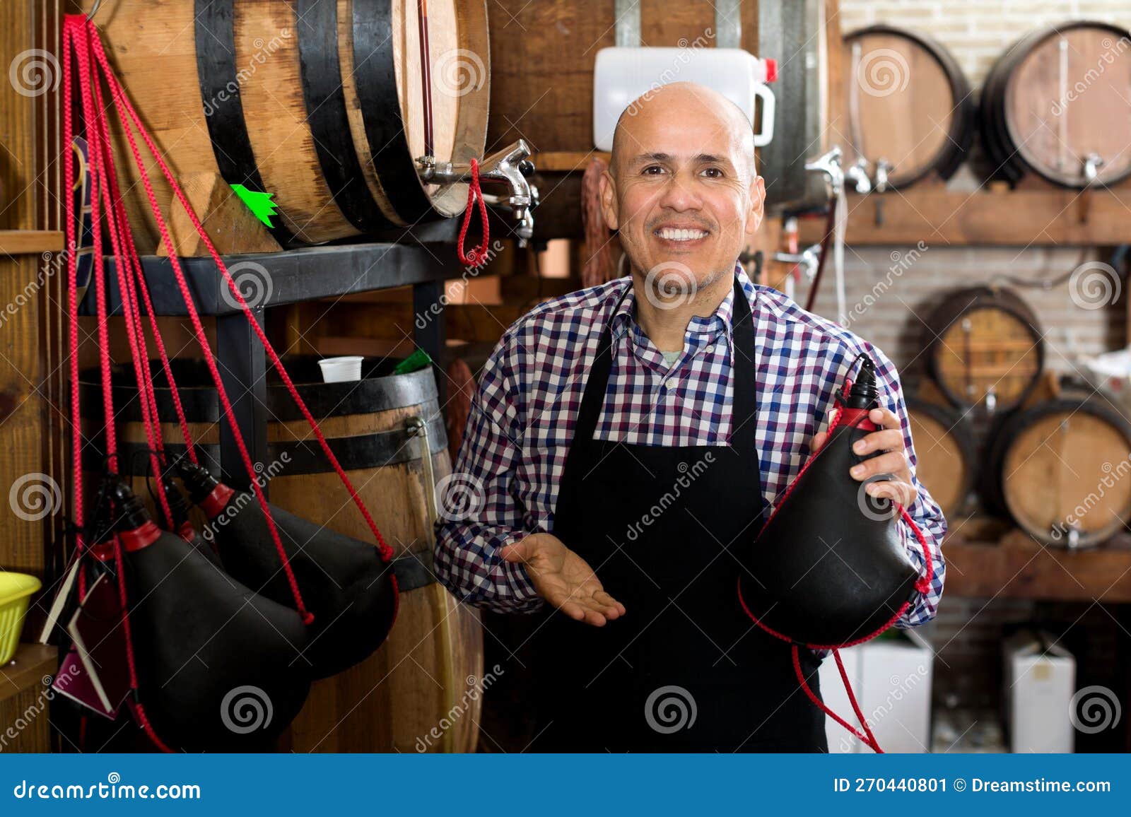 seller holding spanish bota bag for wine