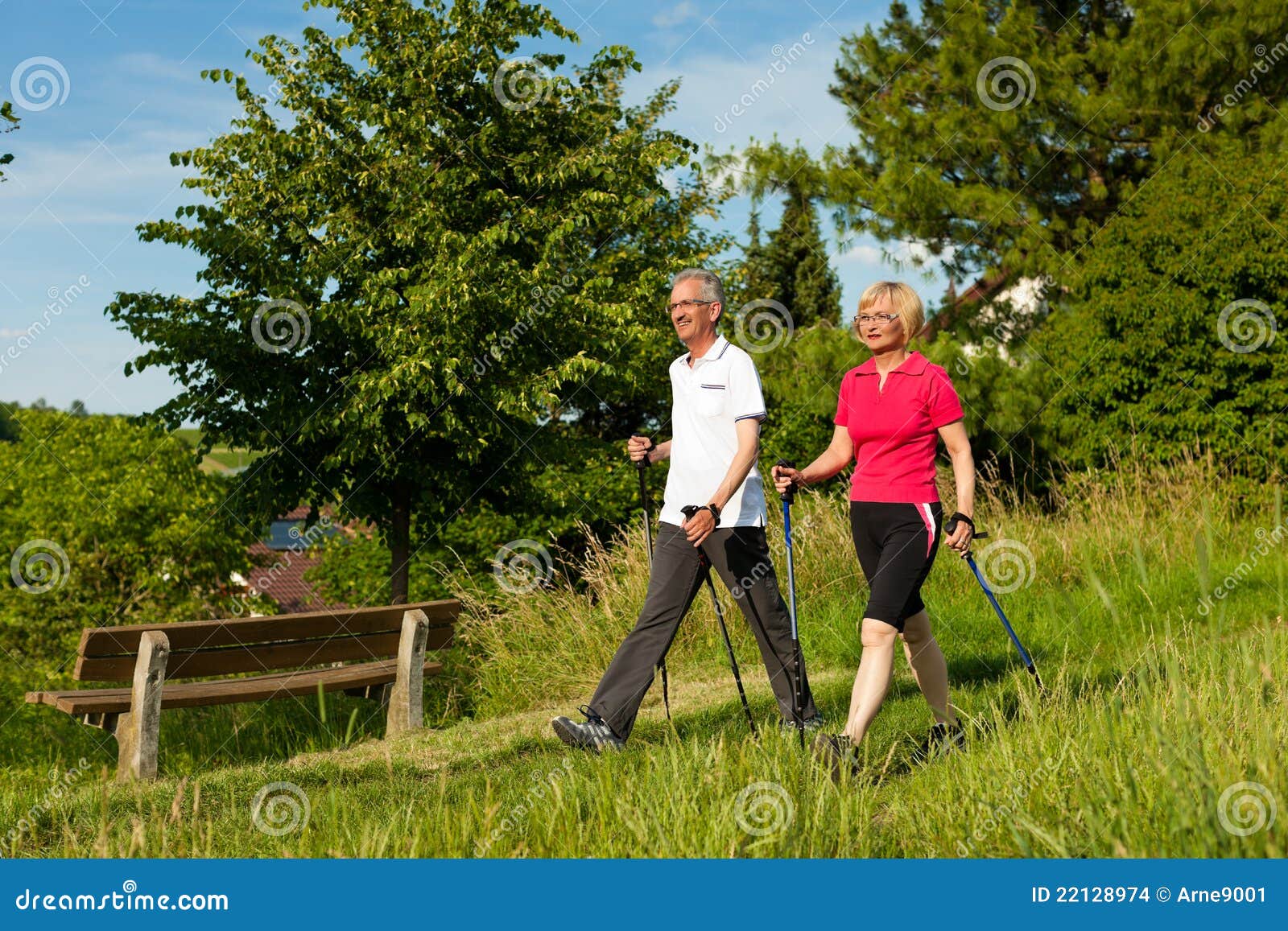 happy mature or senior couple doing nordic walking