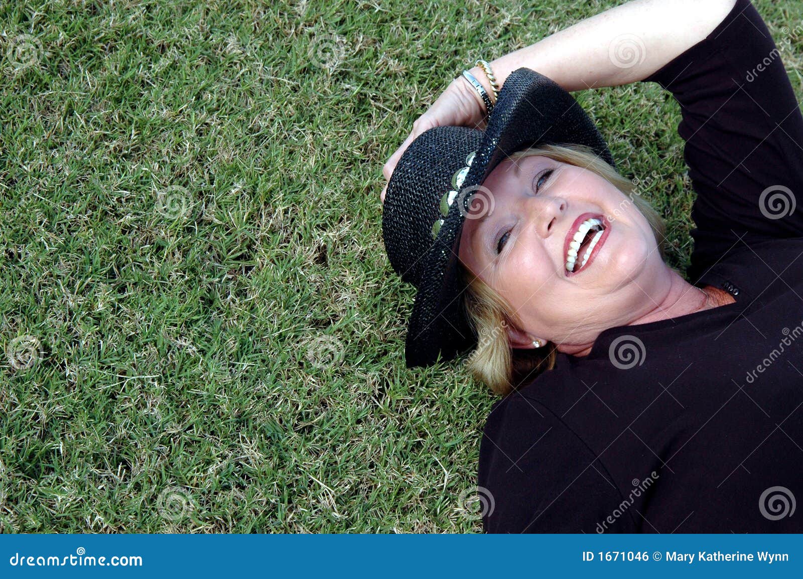 Happy mature woman. Back cowboy grass hat lying mature smiling wearing woman