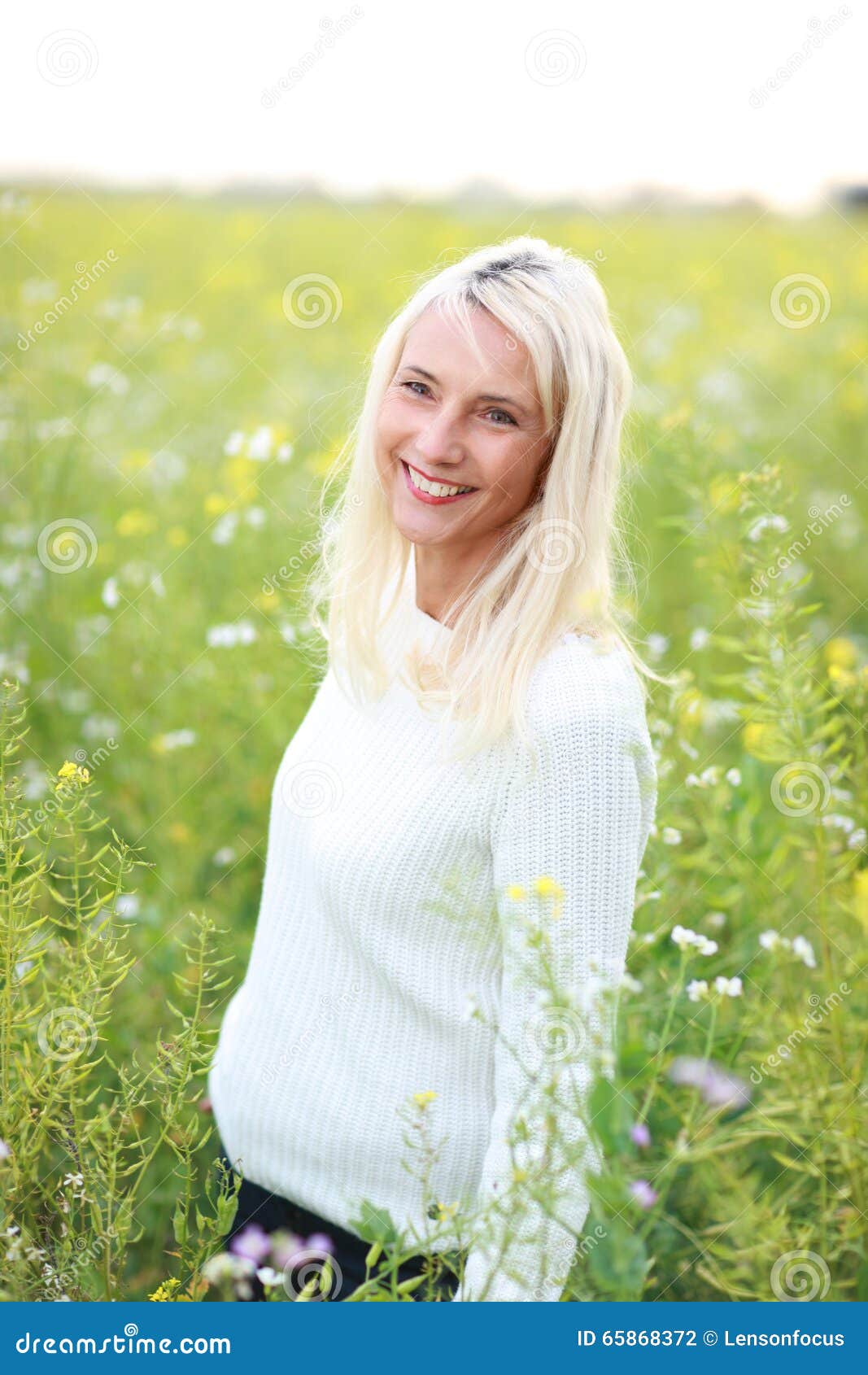 happy matured woman in flowerfield