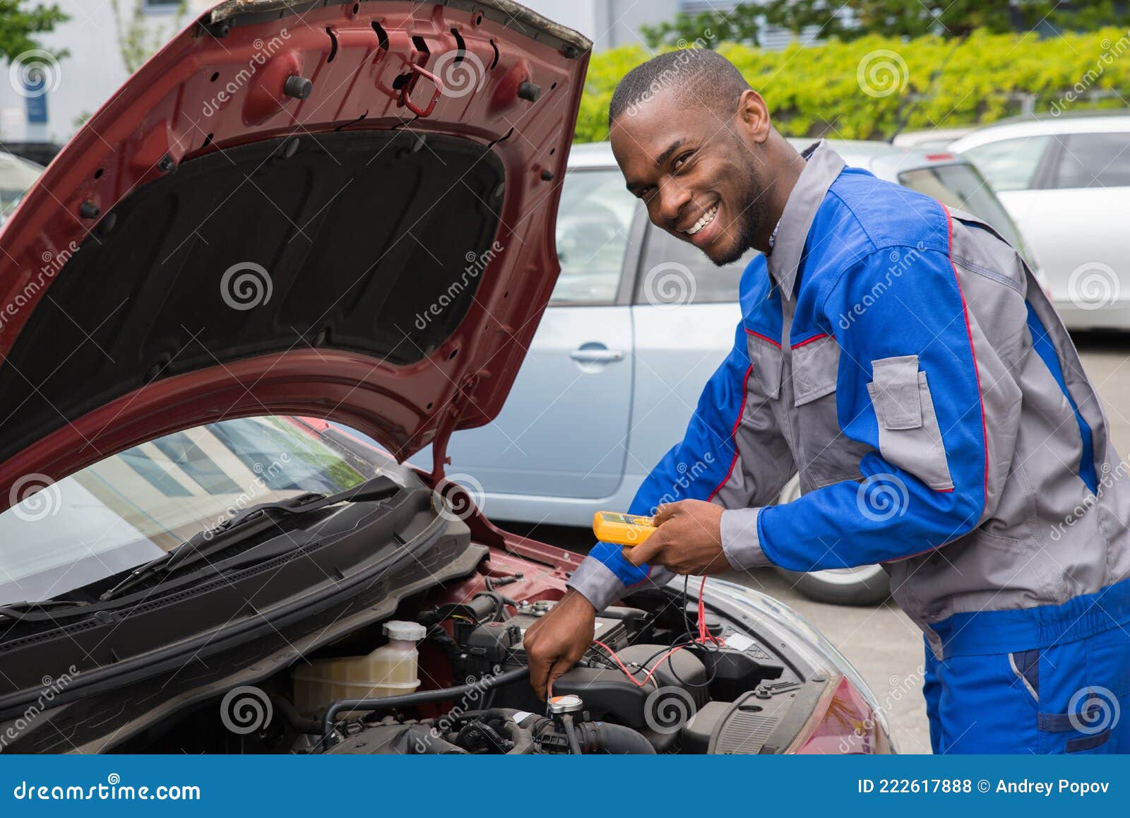 mechanic using multimeter to check car battery