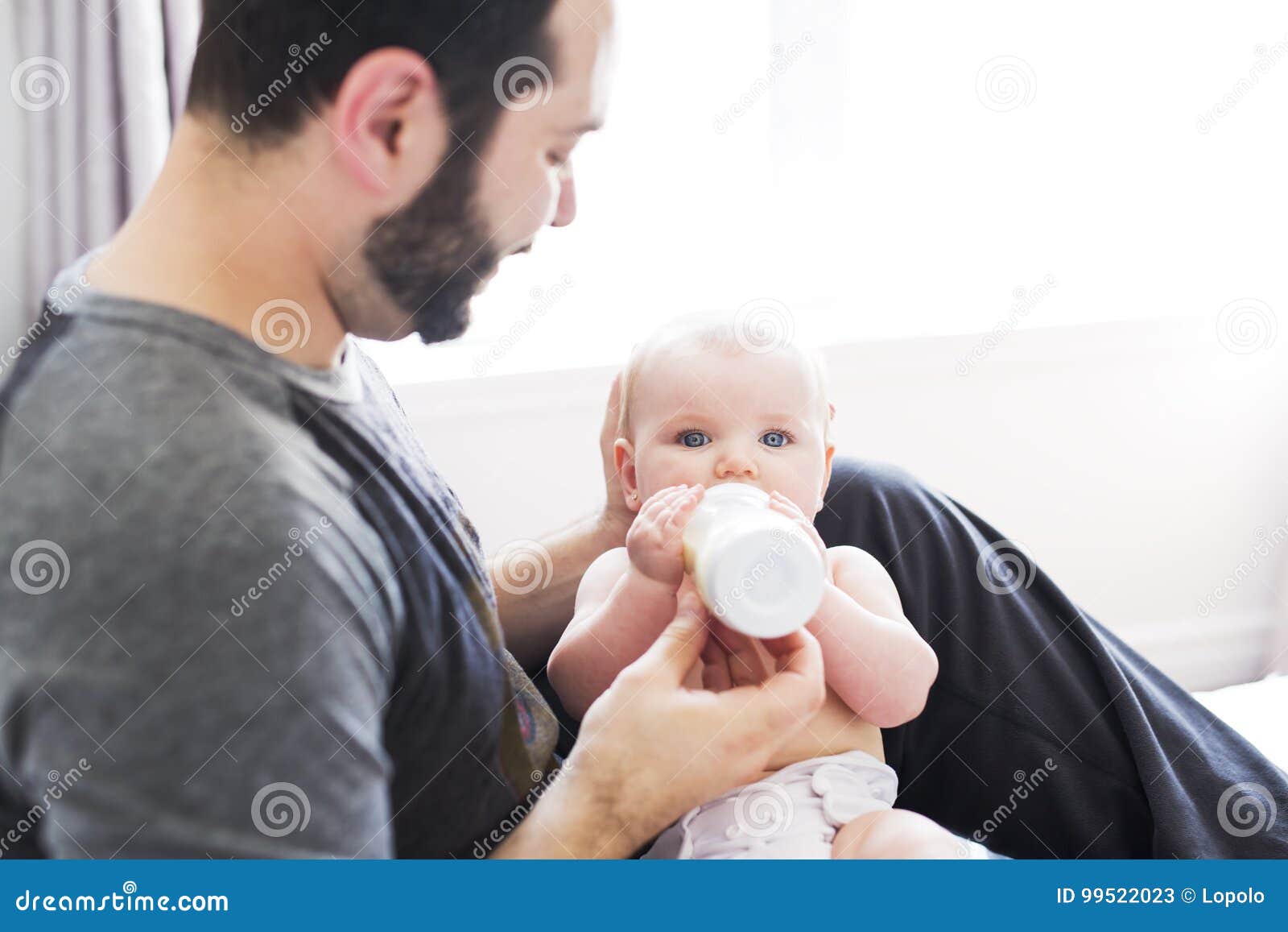 Happy Man Feeding Milk To Baby Girl At Home Stock Image ...