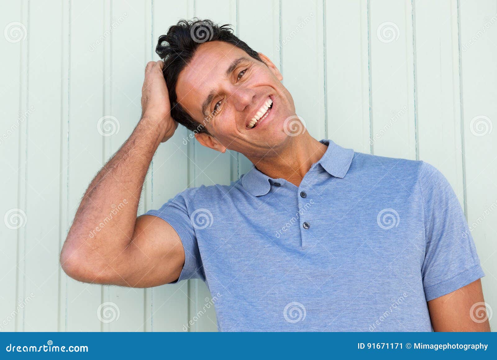 happy middle age man laughing with hand in hair
