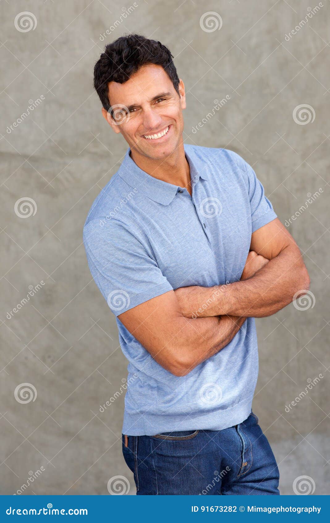 happy middle age man smiling with arms crossed