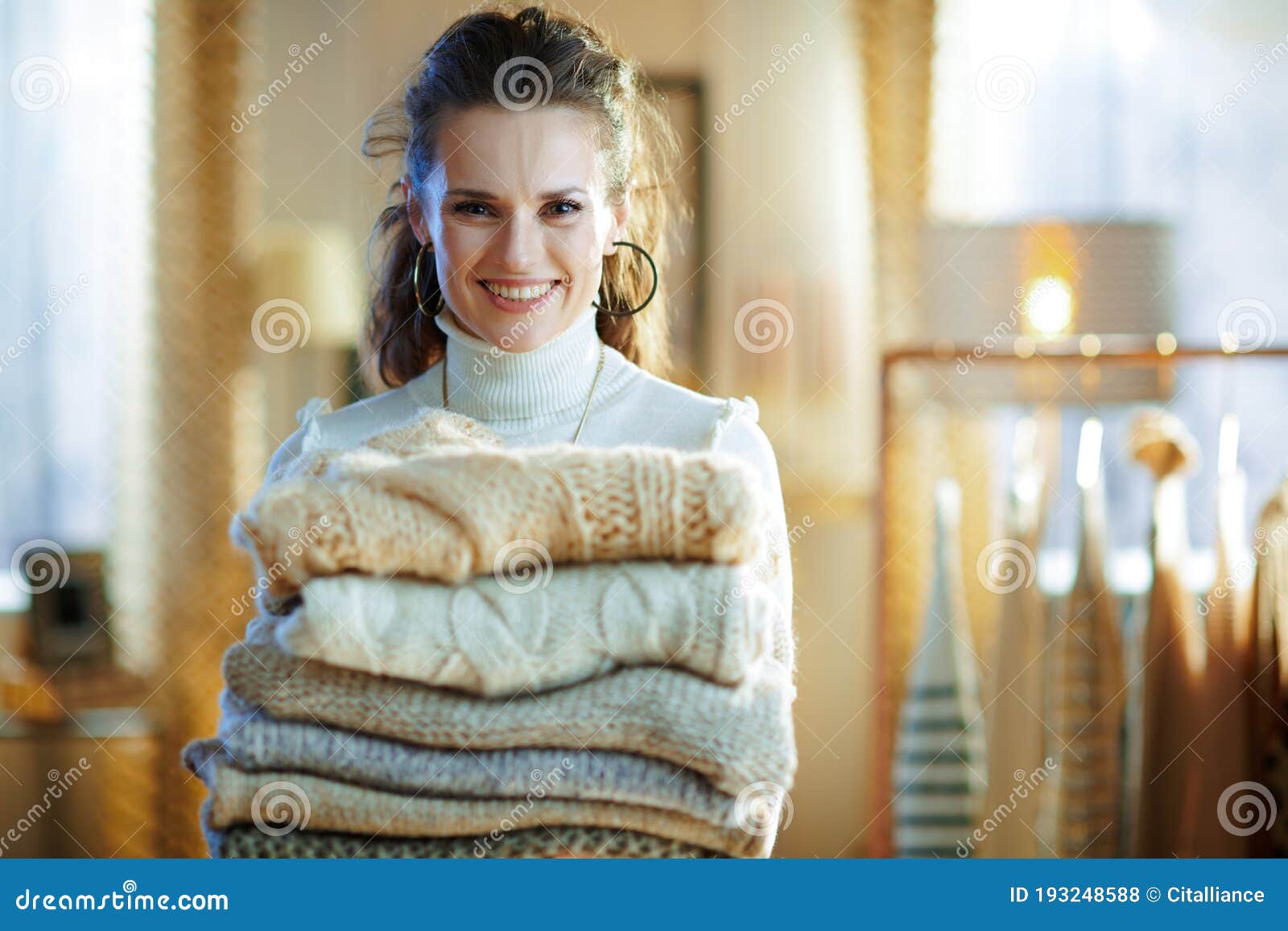 Woman in Modern House in Sunny Winter Day Holding Sweaters Stock Photo ...