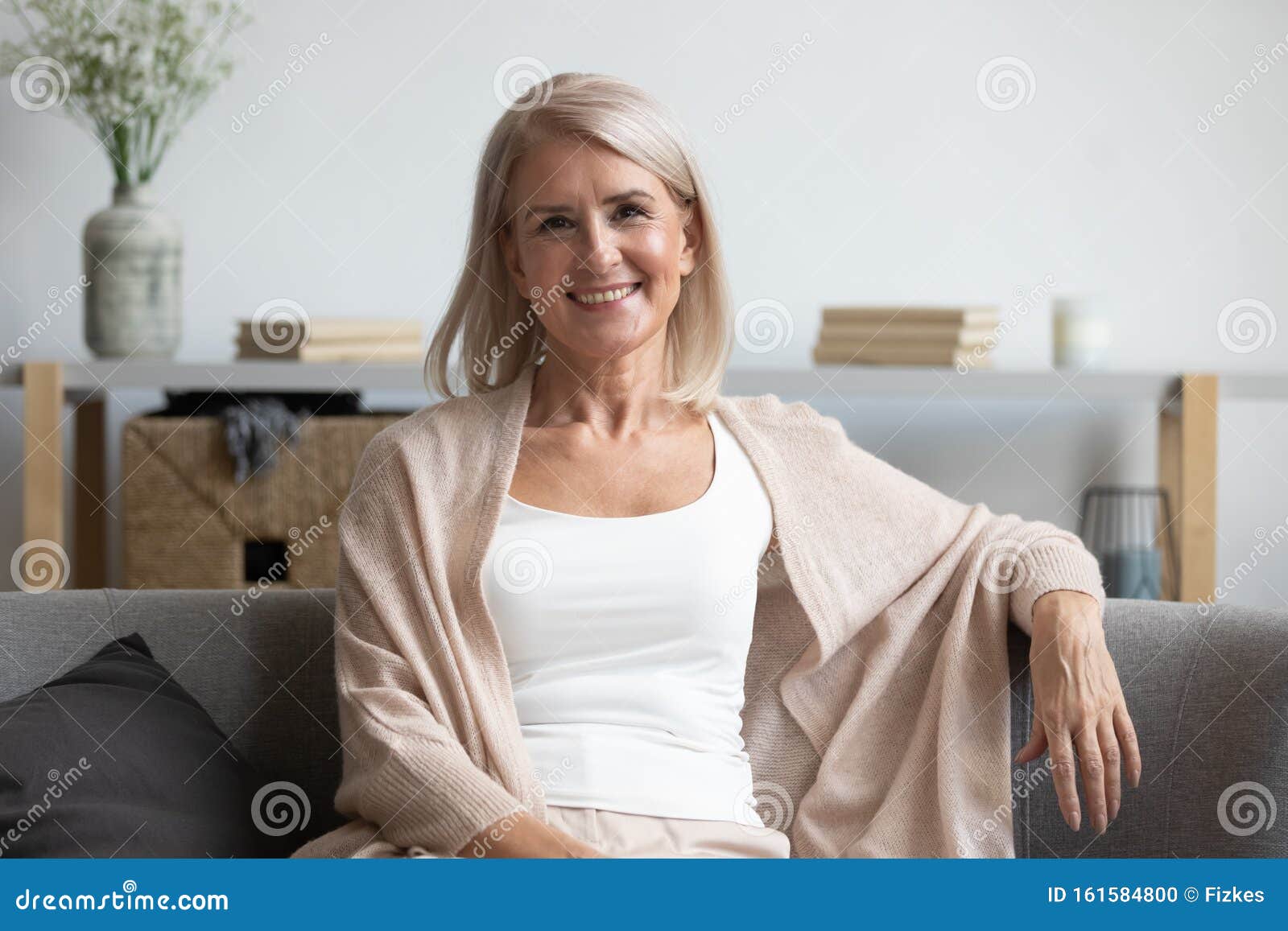 happy middle aged woman looking at camera at home
