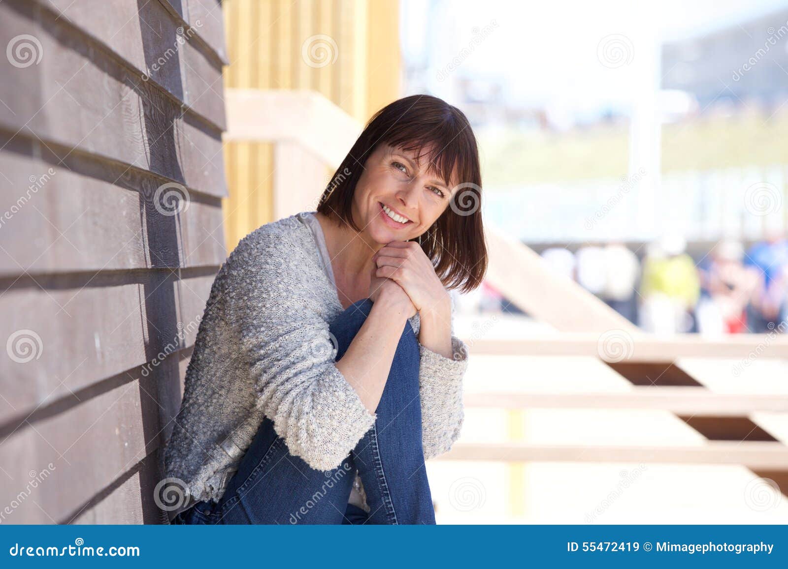 happy middle aged woman sitting outside