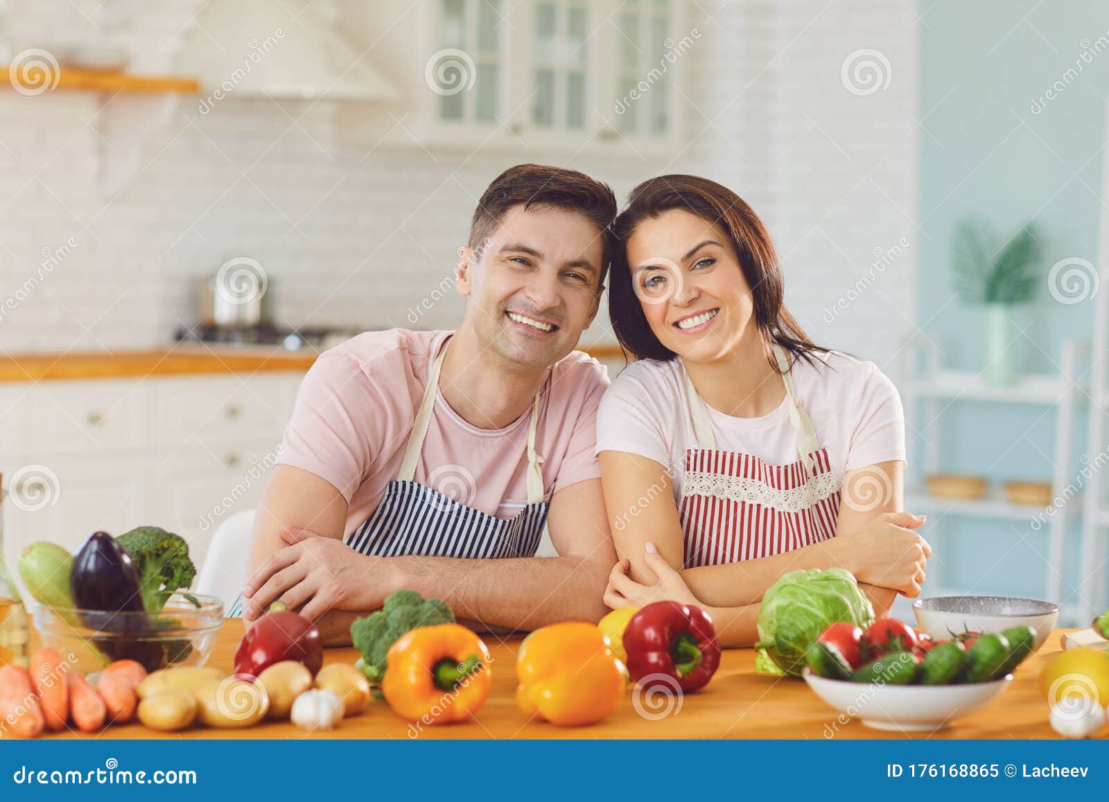 Happy Middle Couple Smiling At A Table With Fresh Vegetables Make Salad