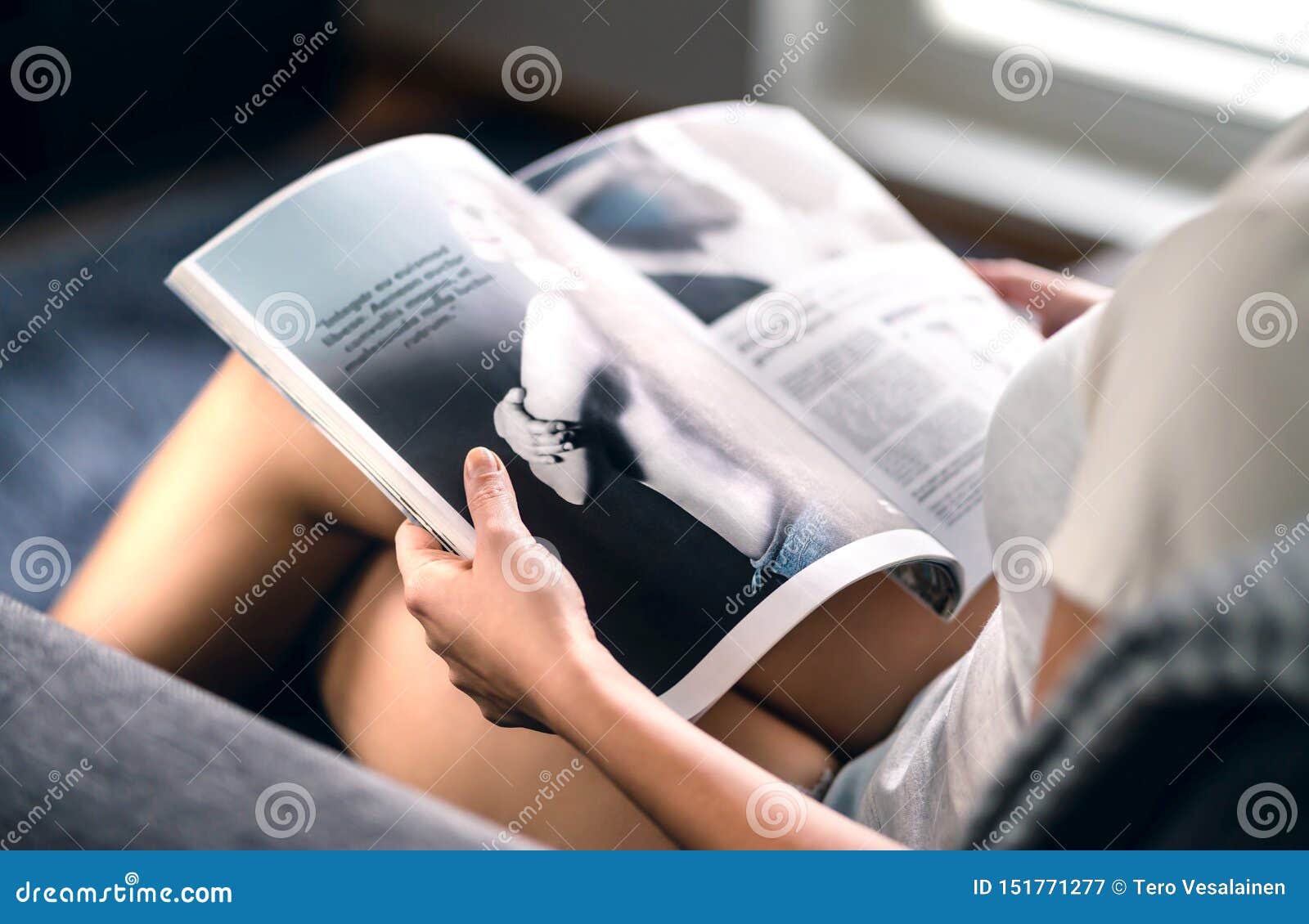 happy millennial lady reading fashion magazine with latest beauty trends or celebrity news and interview articles.