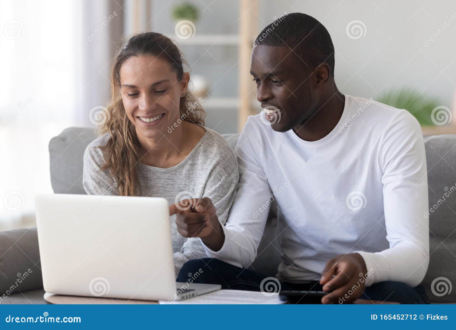 happy mixed race family spouse making monthly budget calculations.