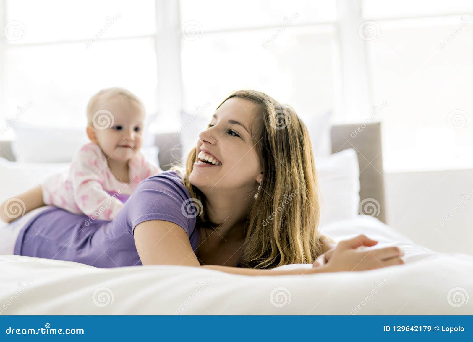 Happy Mother with Baby Lying on Bed at Home Stock Image - Image of ...