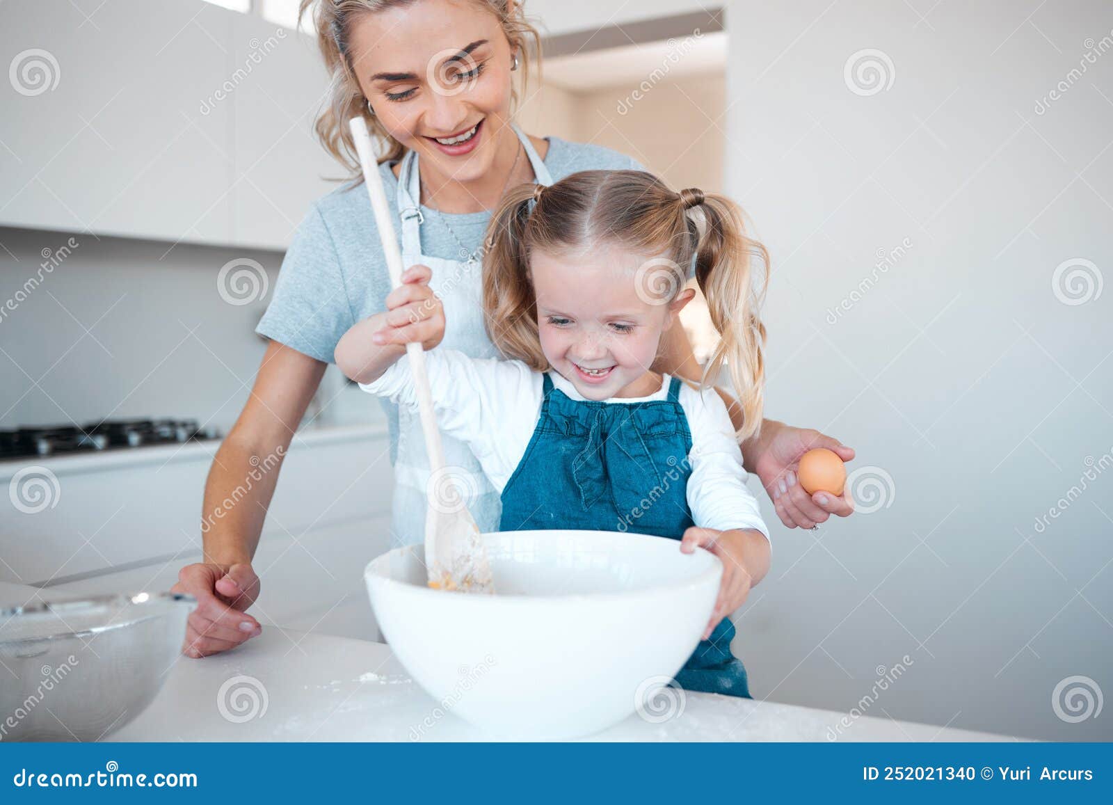 Happy Mother And Daughter Baking And Bonding Young Woman Helping Her Daughter Bake At Home