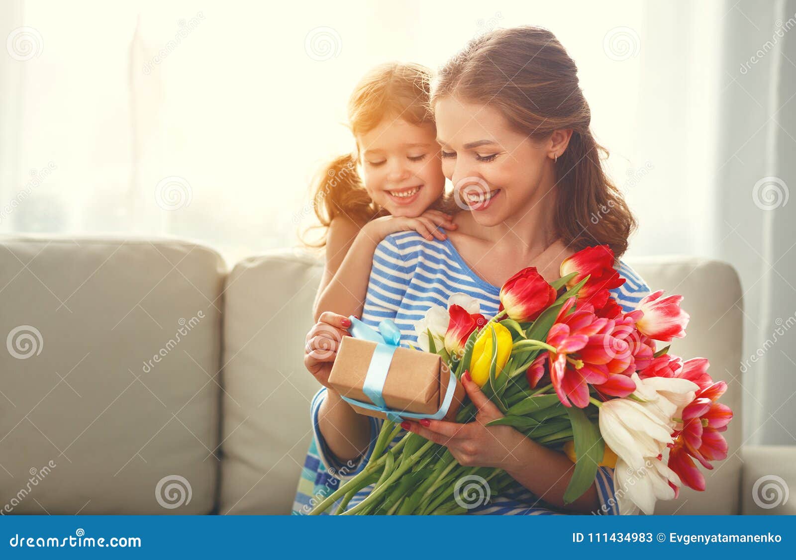 happy mother`s day! child daughter gives mother a bouquet of f