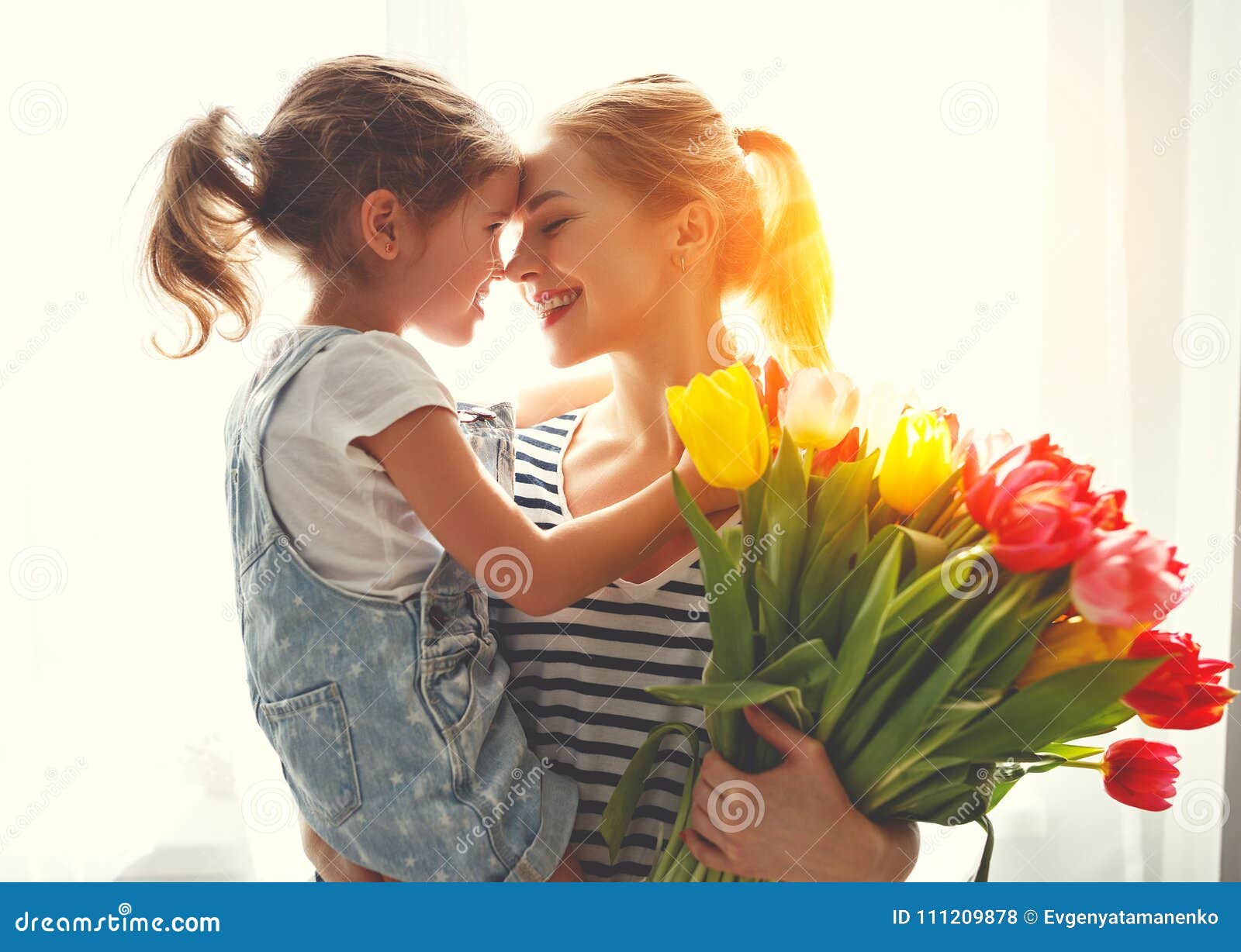 happy mother`s day! child daughter gives mother a bouquet of f