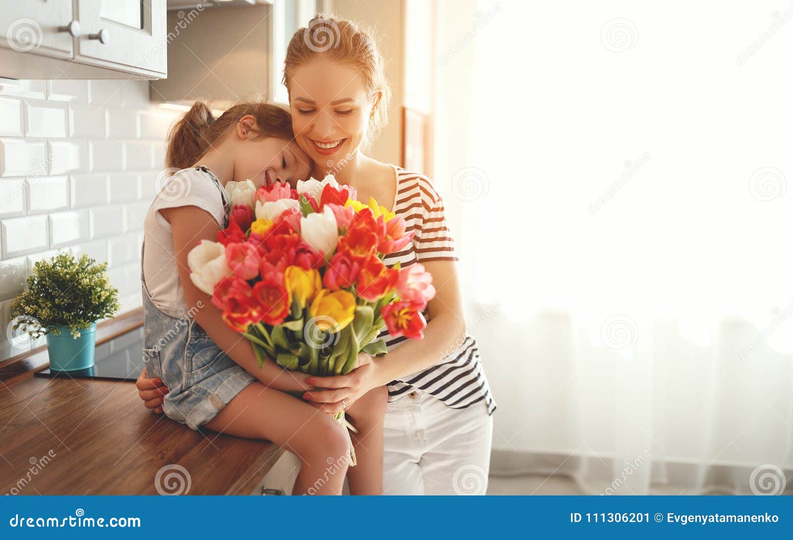 happy mother`s day! child daughter gives mother a bouquet of f