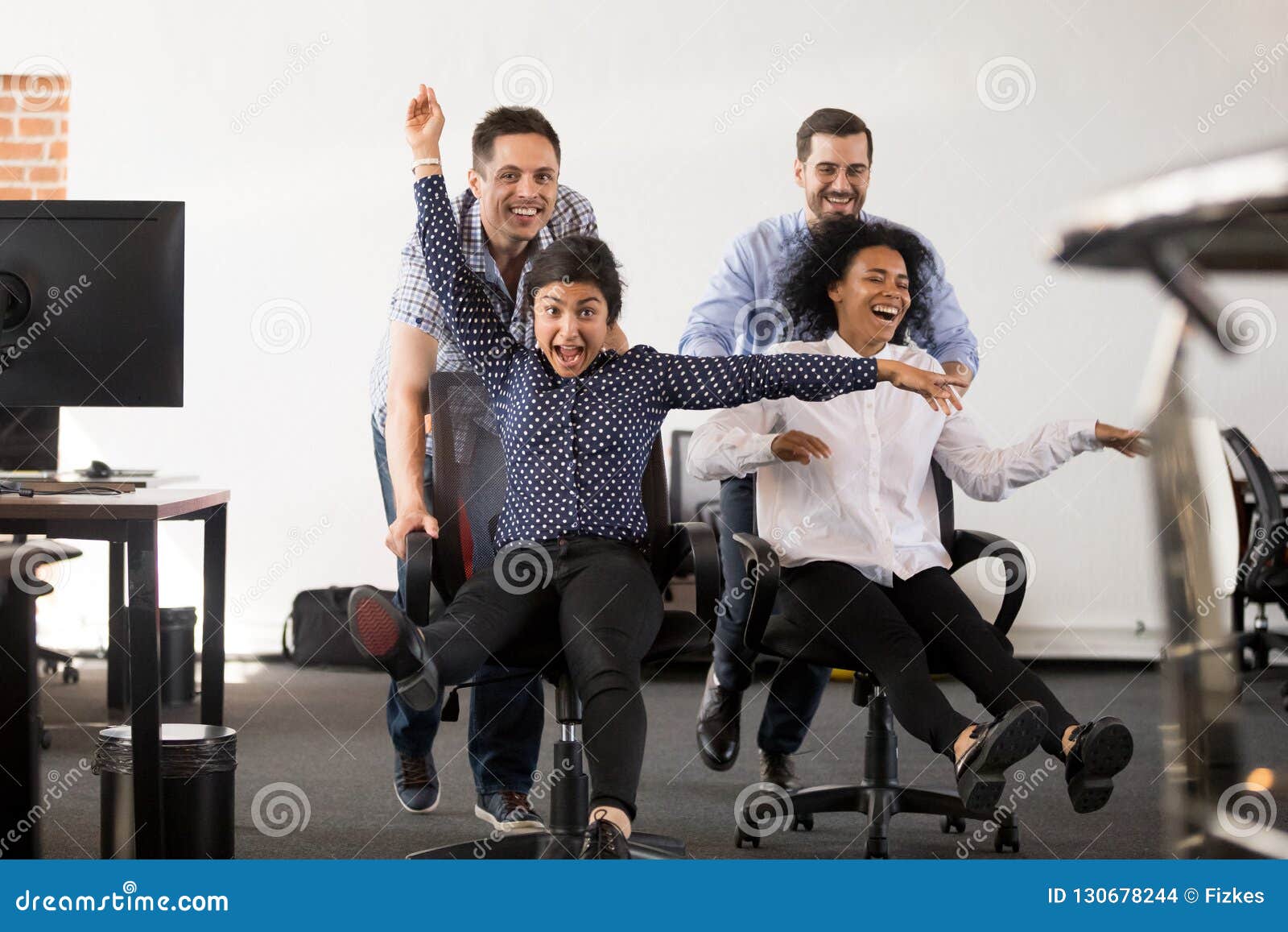 Happy Multi Ethnic Office People Having Fun Riding On Chairs Stock Photo Image Of Motivated Lifestyle 130678244
