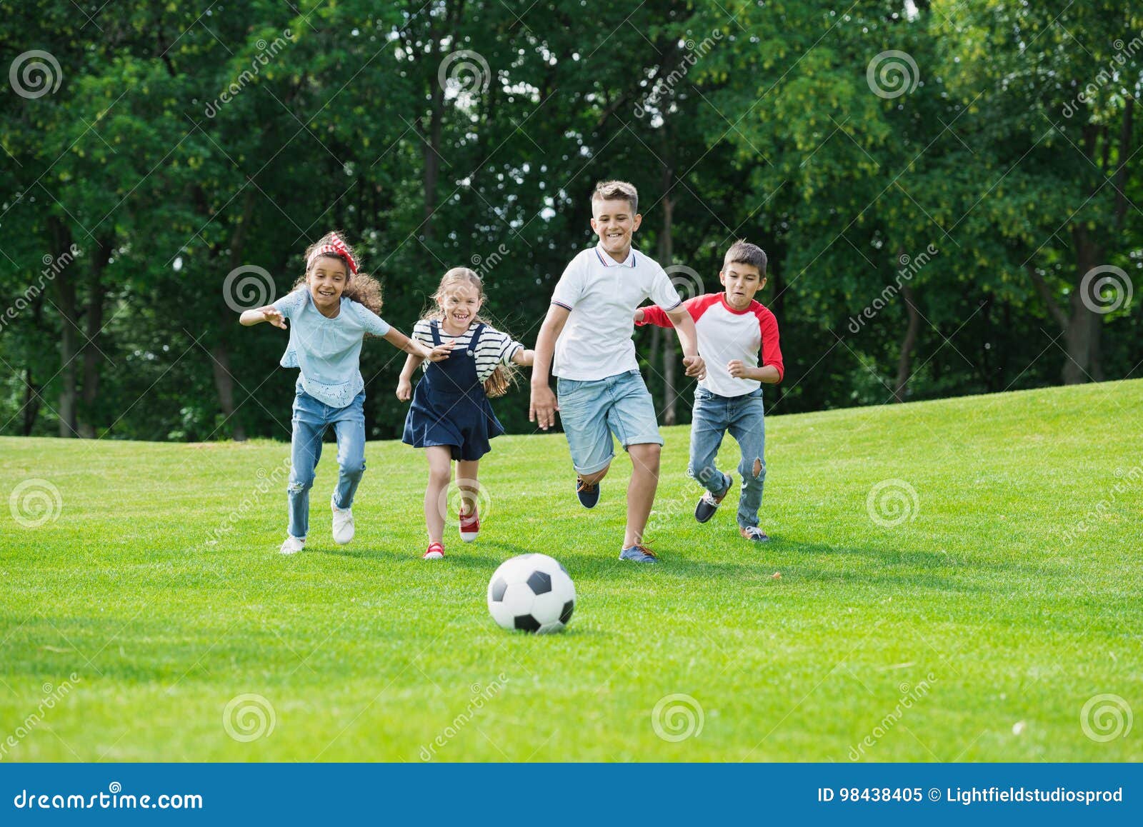 Happy Multiethnic Kids Playing Soccer With Ball In Park Royalty Free happy-multiethnic-kids-playing-soccer-with-ball-in-park-royalty-free
