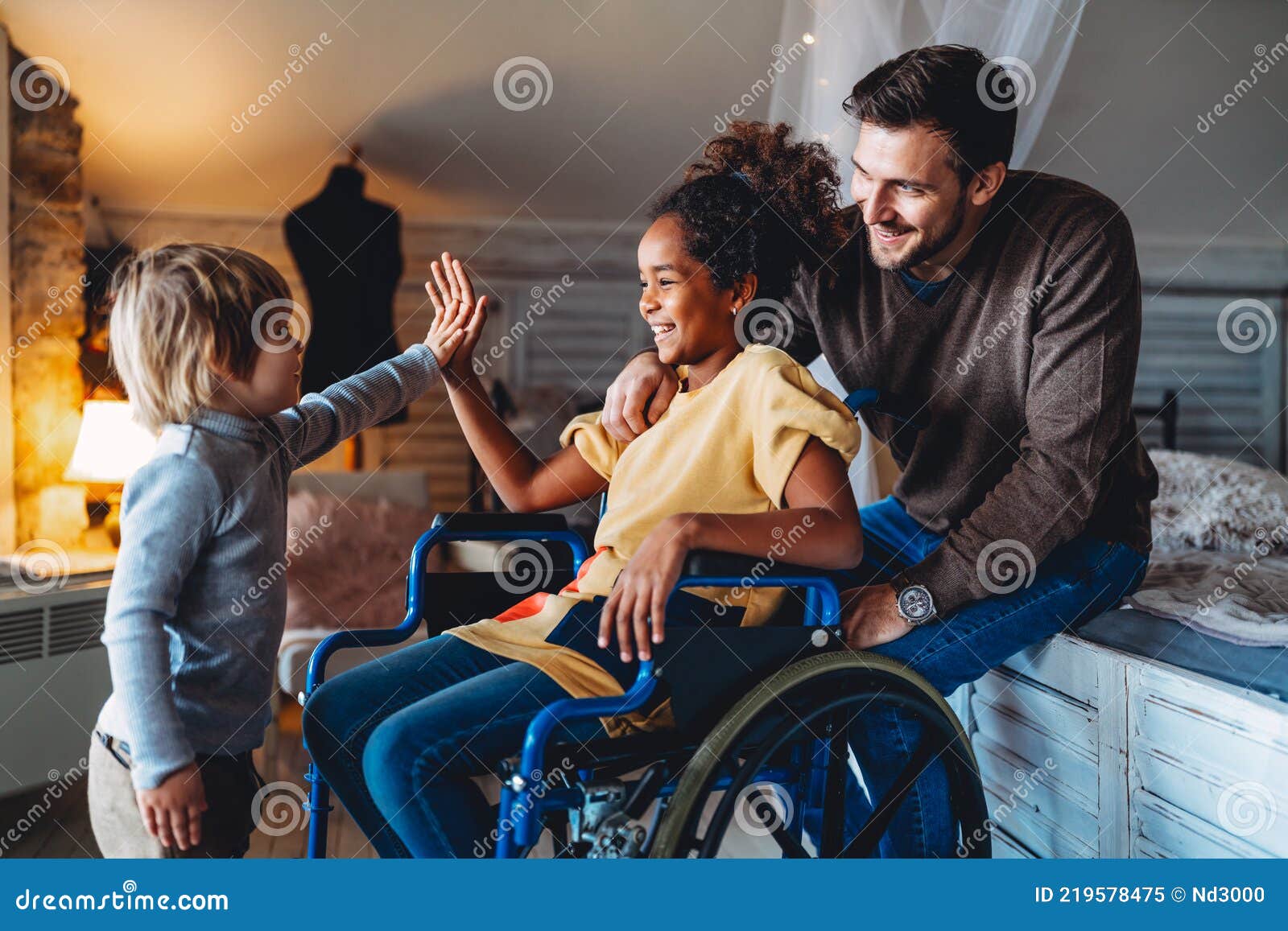 happy multiethnic family. smiling little girl with disability in wheelchair at home