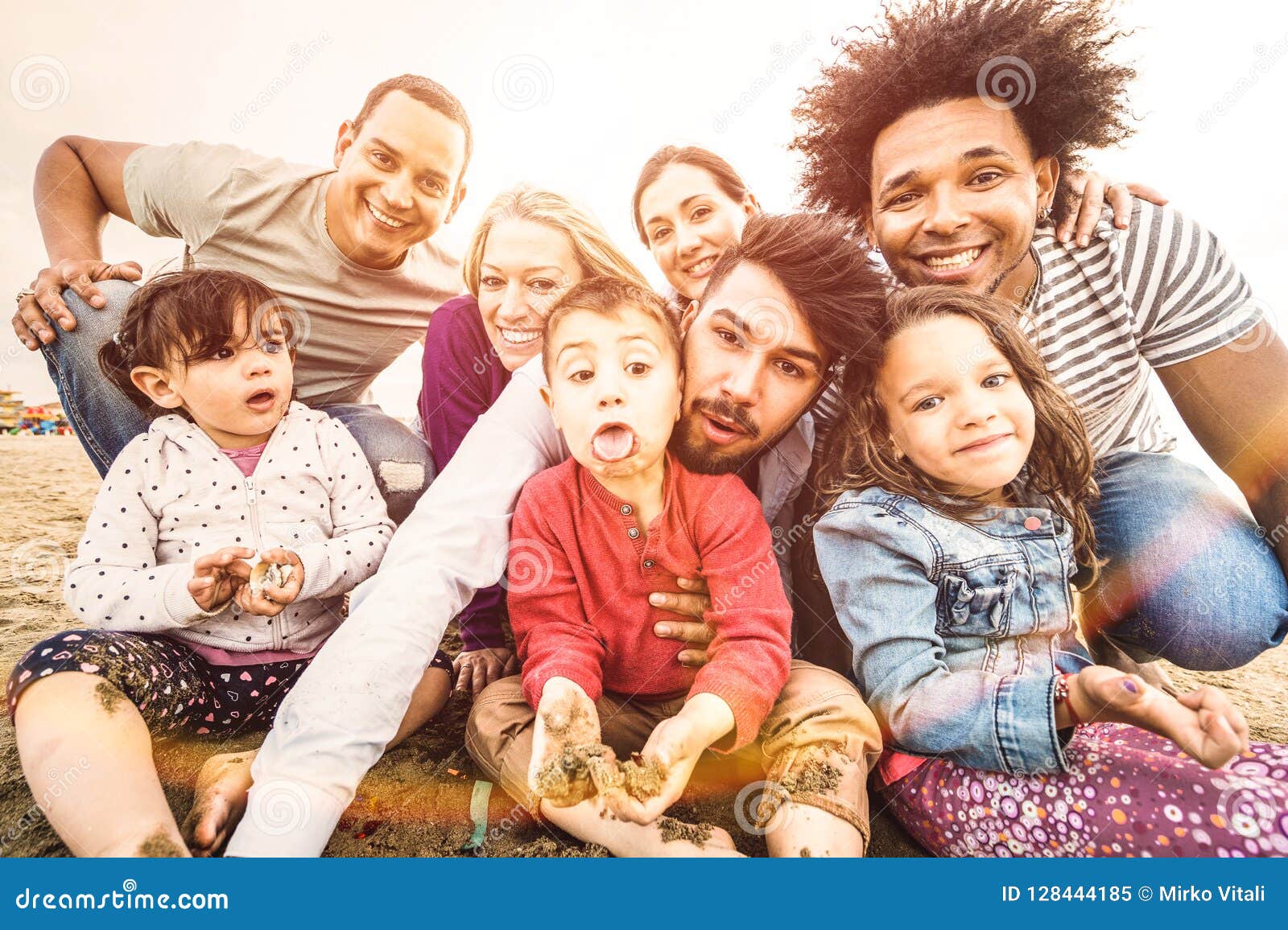 happy multiracial families taking selfie at beach making funny faces