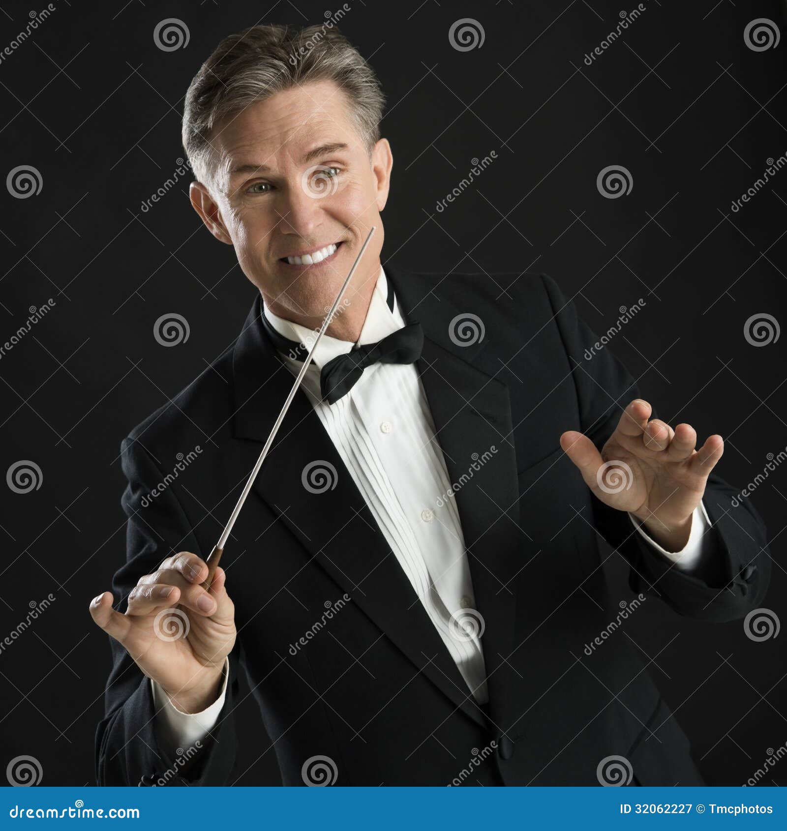 happy music conductor gesturing while directing with his baton