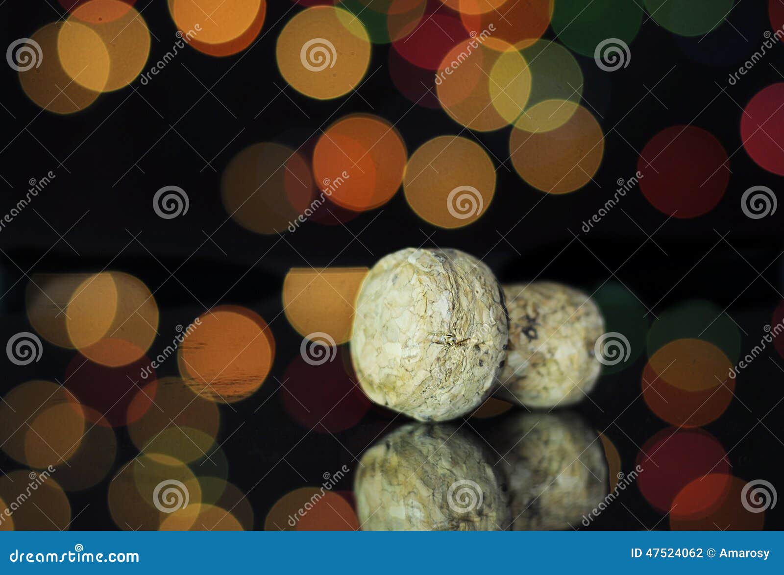 Happy New Year Eve party with closeup on champagne bottle cork on reflective table against bright color festive bokeh lights.