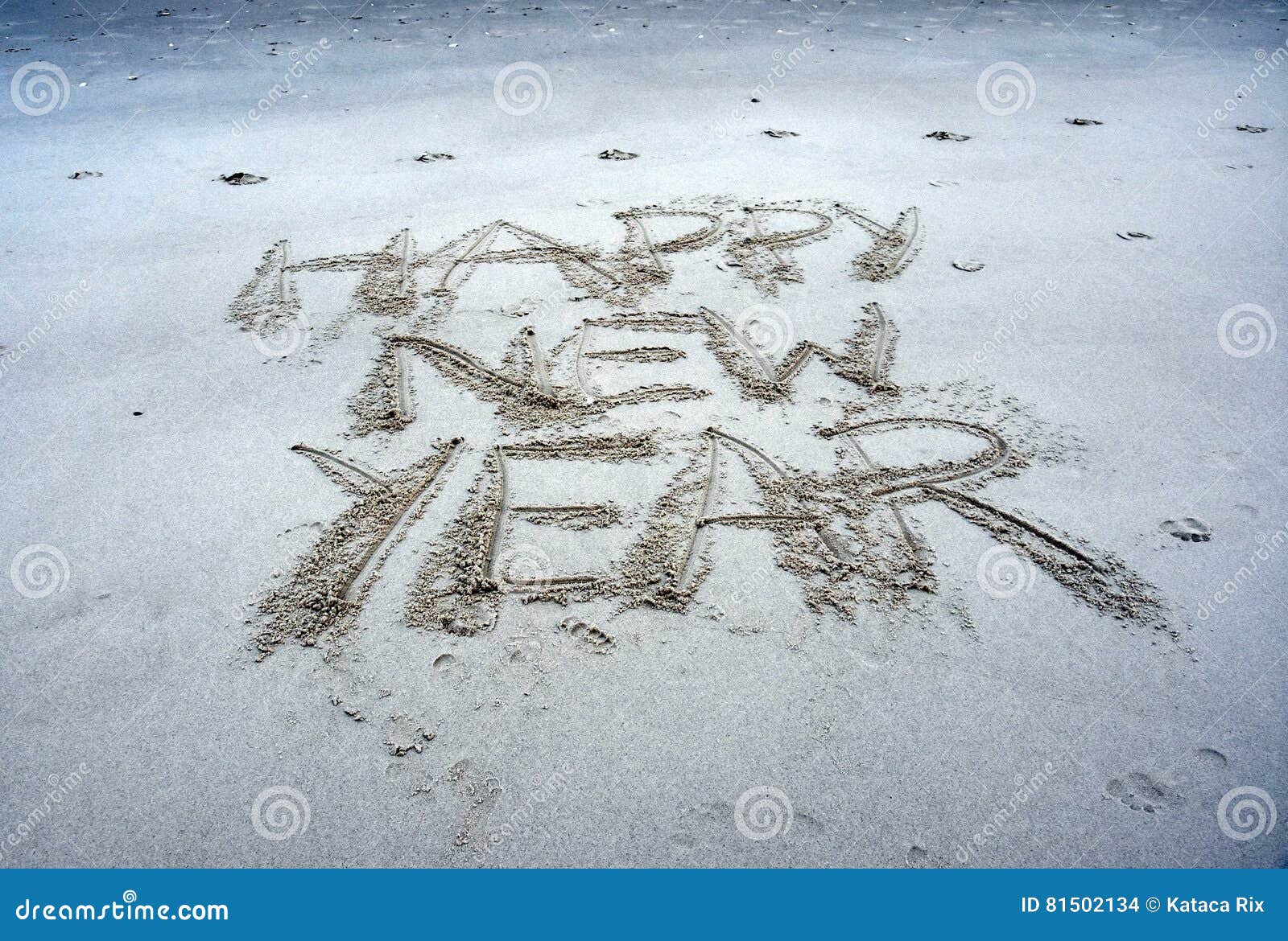 happy-new-year-lettering-beach-written-sand-sunset-drawn-sand-closeup-81502134.jpg