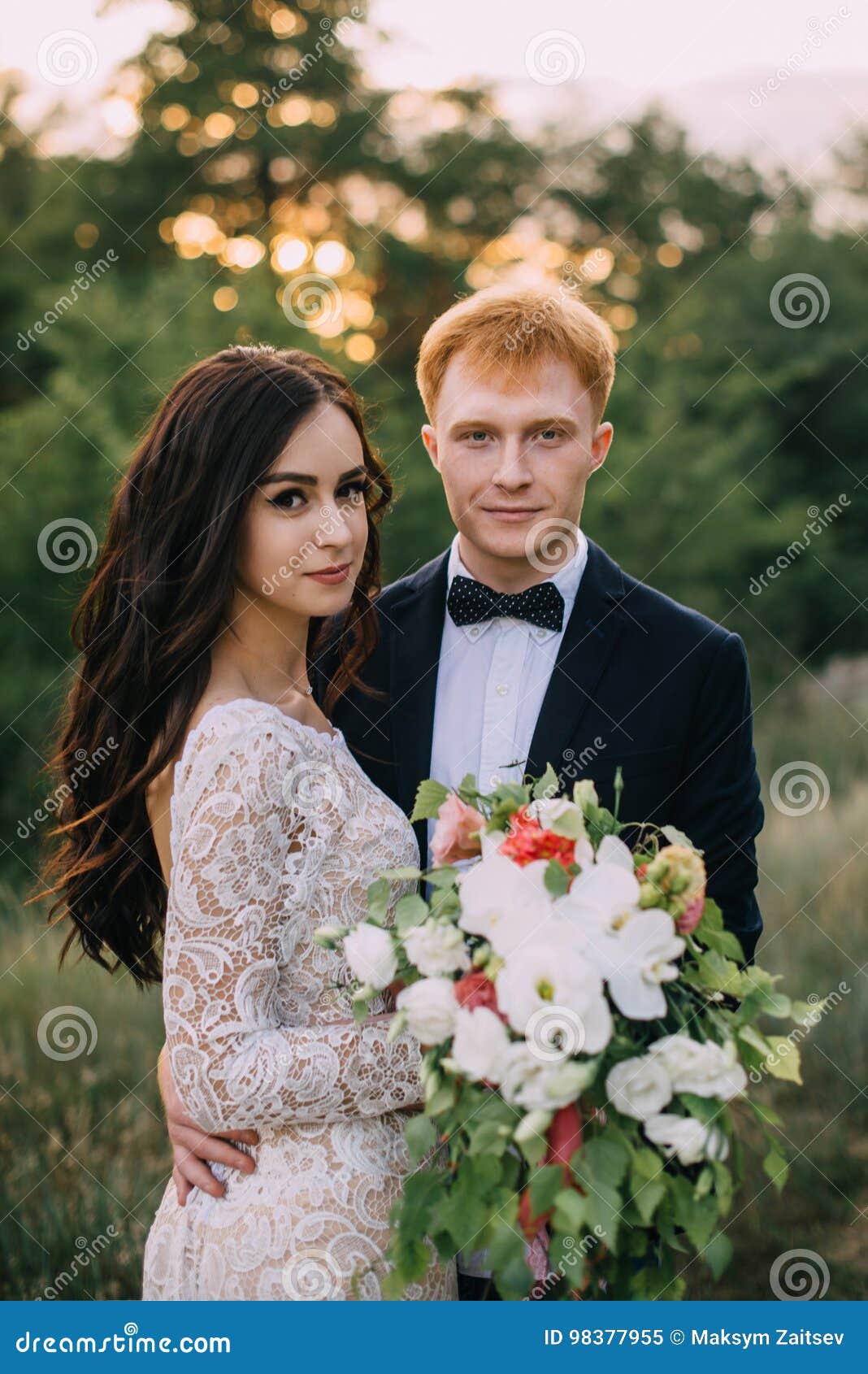 happy newlyweds standing and hugging