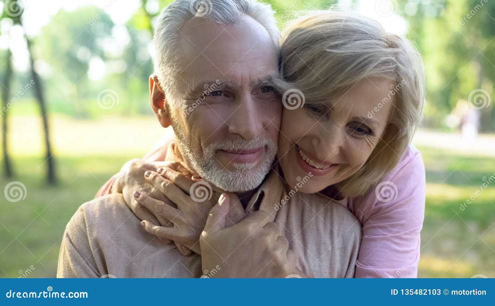 happy old couple hugging, resting in park together, grandparents closeness