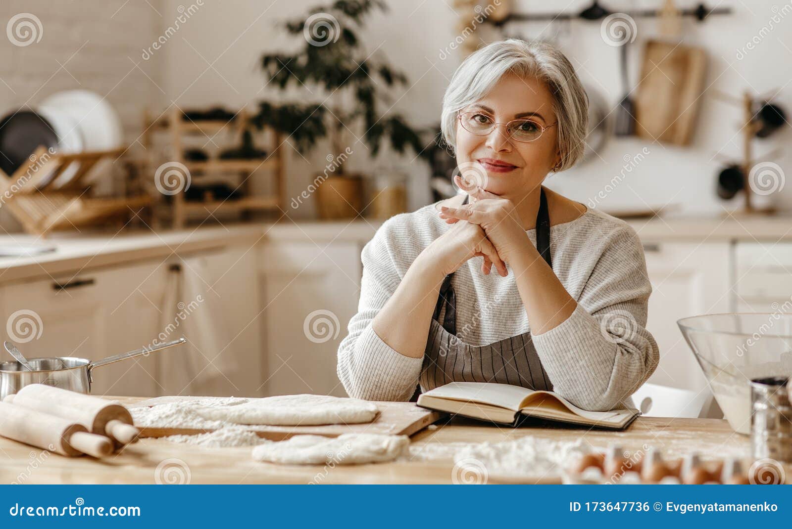 Happy Old Woman Granny Cooks In Kitchen Kneads Dough Bakes Cookies