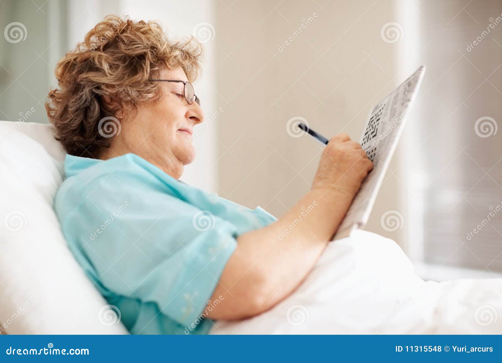 Happy Old Woman Solving a Crossword Puzzle in Bed Stock Photo Image Happy Old Woman Solving a Crossword Puzzle in Bed Stock Photo Image
