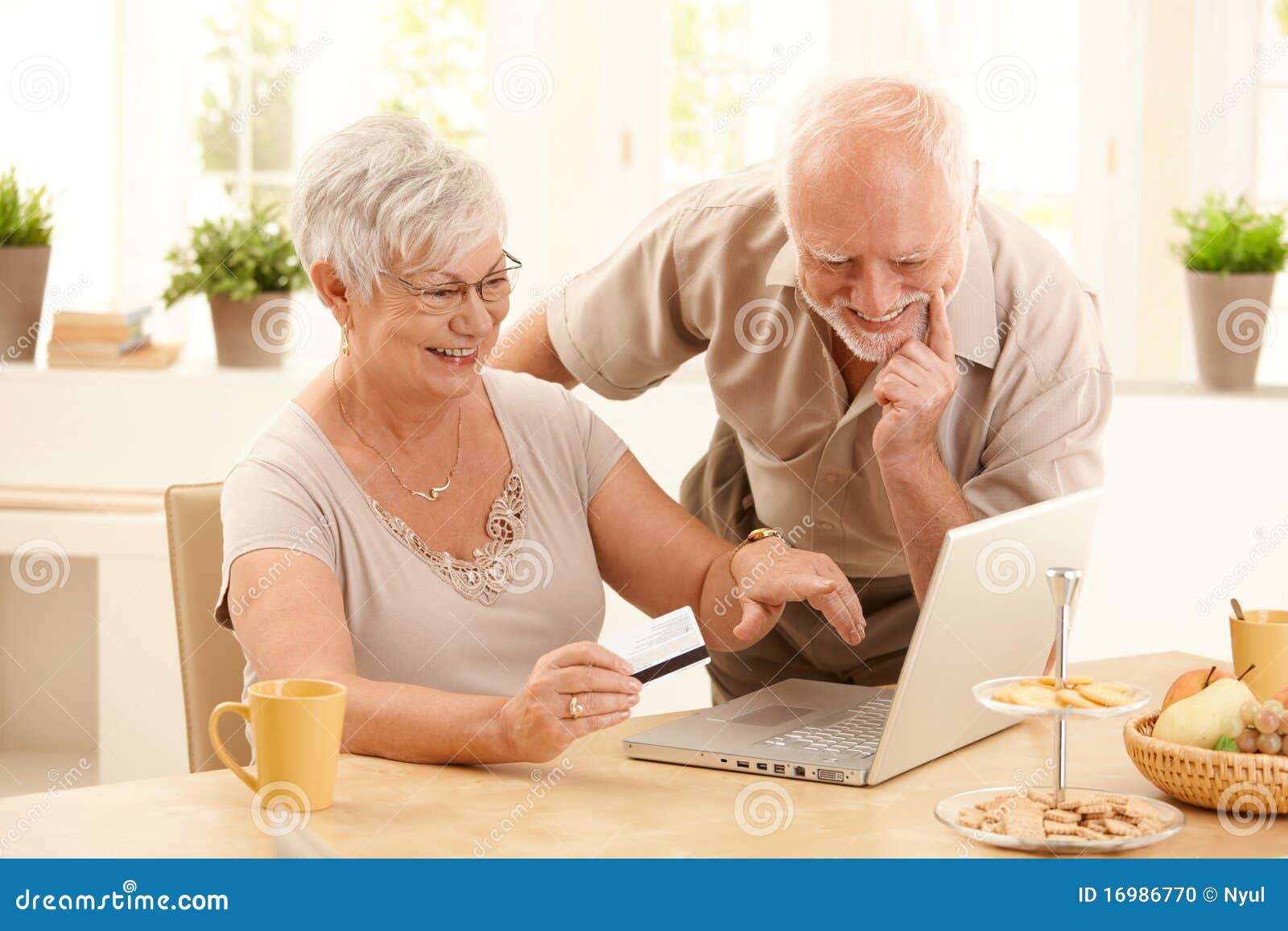 happy older couple doing online shopping