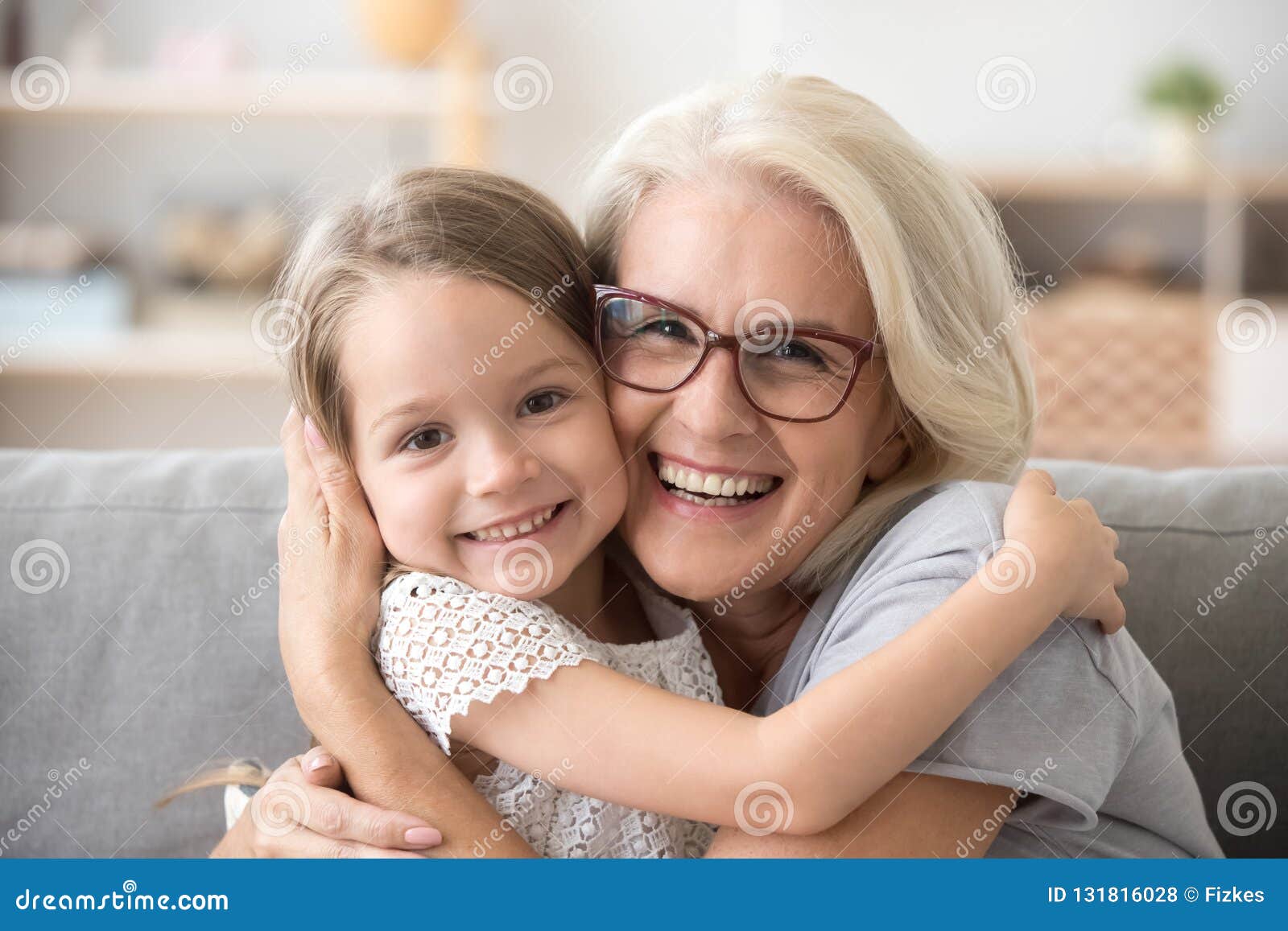 happy older grandmother hugging little grandchild girl looking a