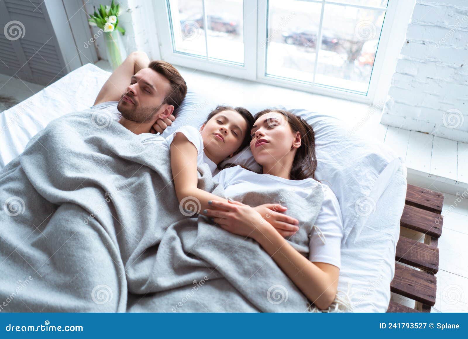The Happy Parents with a Girl Sleeping on the Bed. Stock Image Image